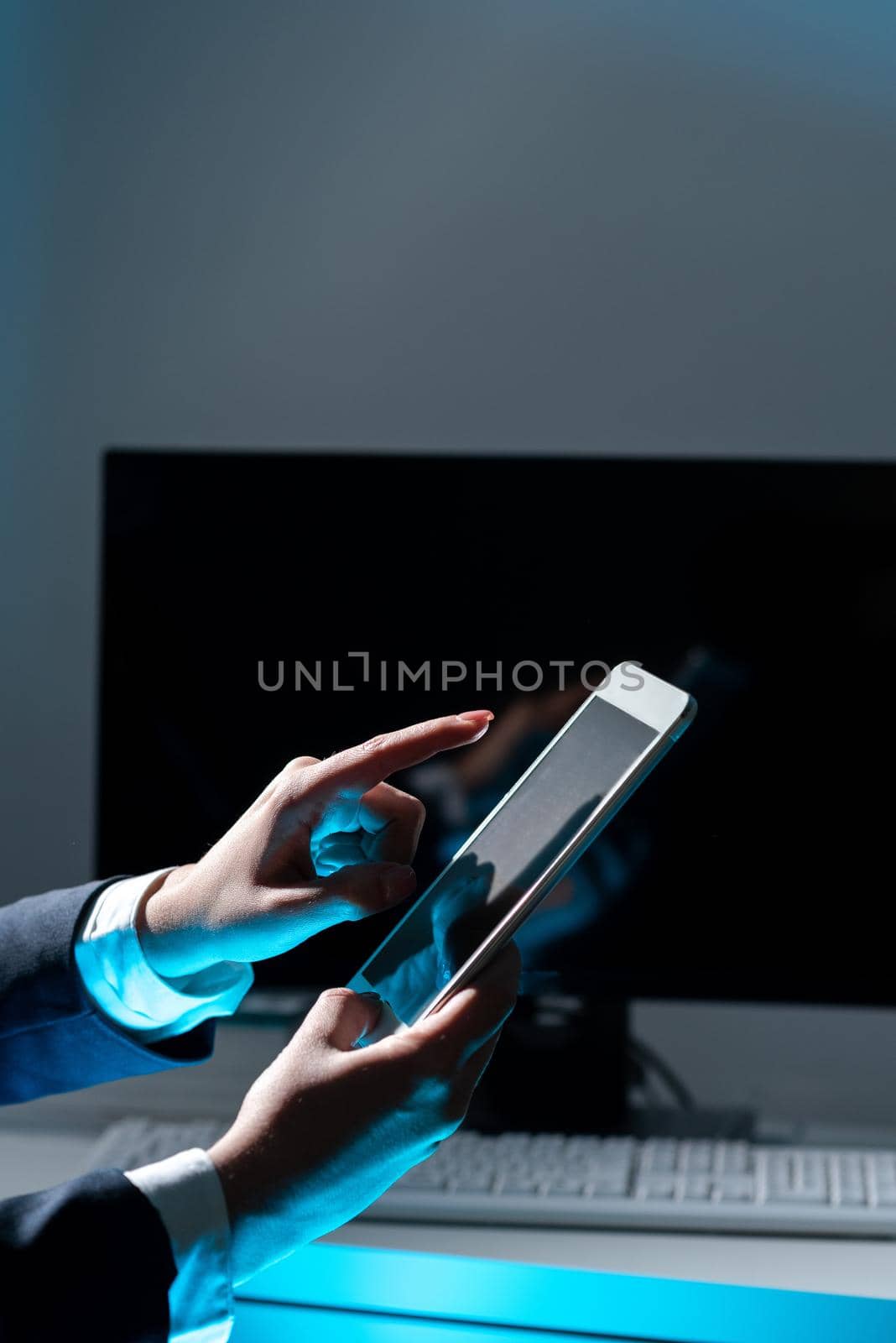 Businesswoman Holding Tablet And Pointing With One Finger On Important Message. Executive In Suit Presenting Crutial Information. Woman Showing Critical Announcement. by nialowwa