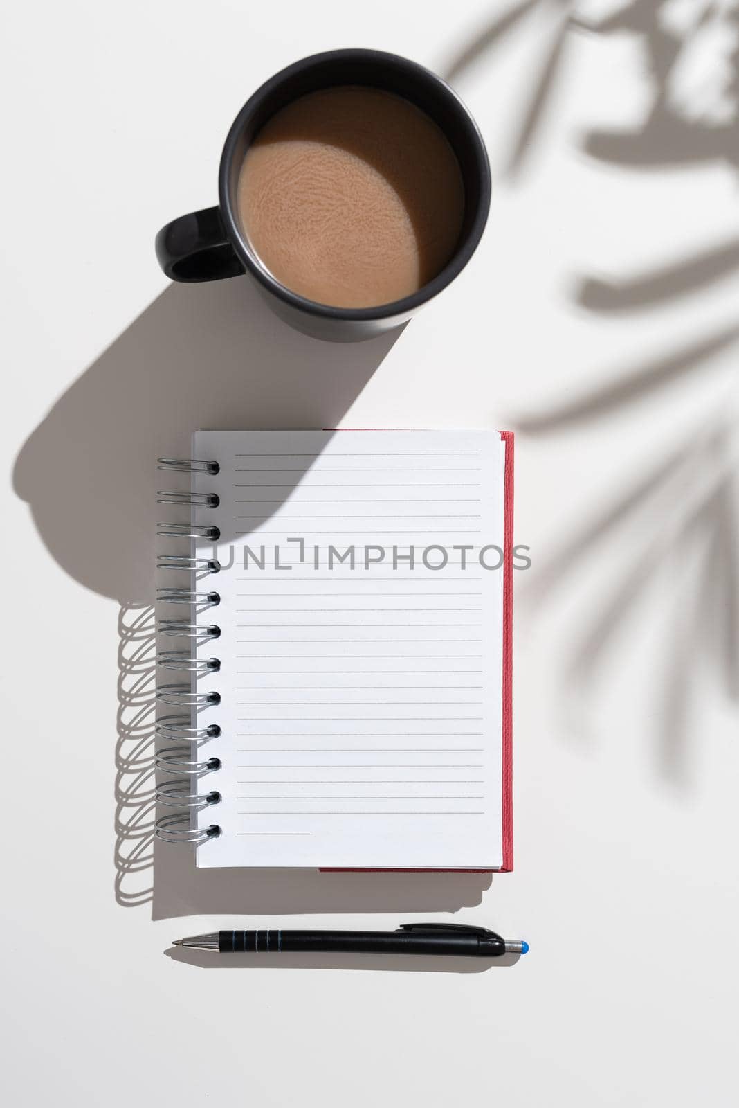 Notebook With Important Messages On Desk With Coffee And Pen. Crutial Informations Written On Pad On Table With Cup And Pencil. Late Updates Presented. by nialowwa