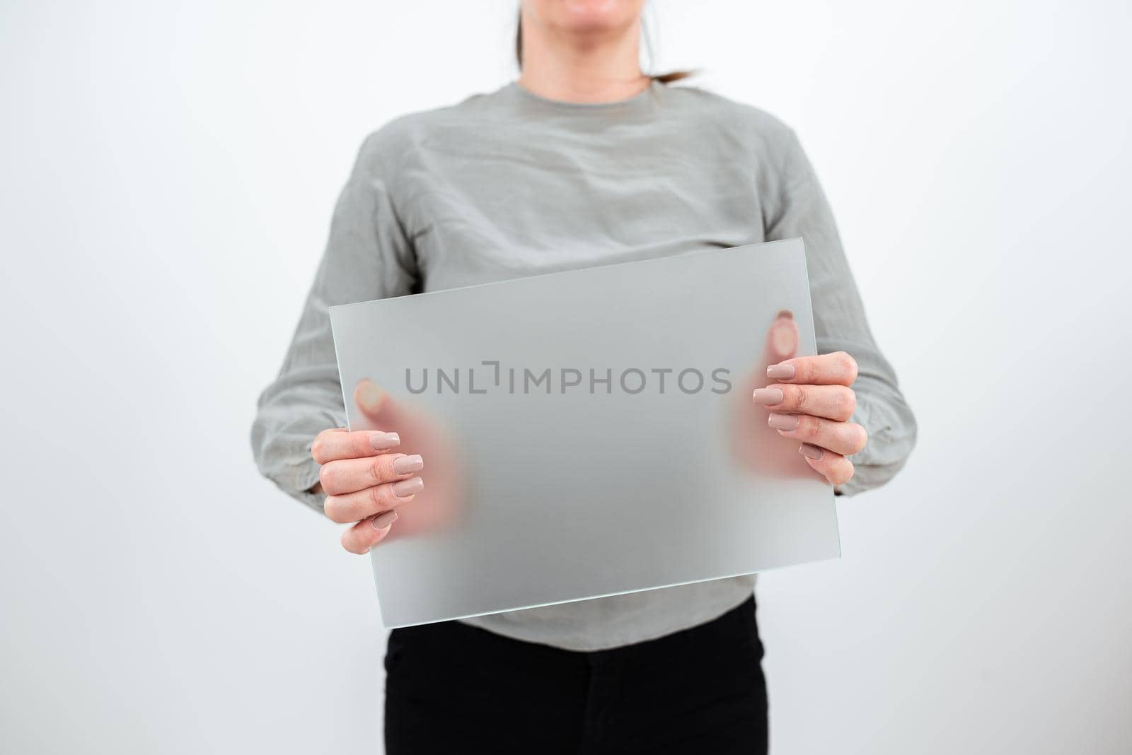 Businesswoman Holding Blank Placard And Presenting Important Sales Data. Female Worker Wearing Smart Casual And With Banner In Hands Advertising The Business. by nialowwa