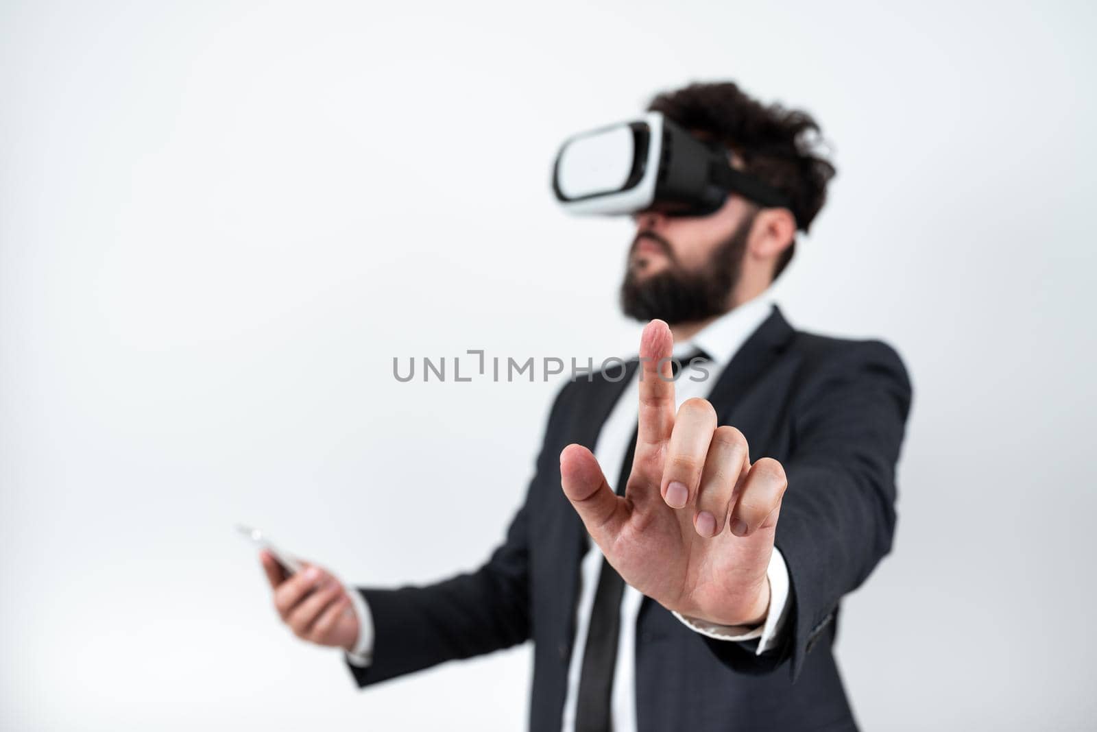 Man Wearing Vr Glasses And Pointing On Important Messages With One Finger. Businessman Having Virtual Reality Eyeglasses And Showing Crutial Informations. by nialowwa