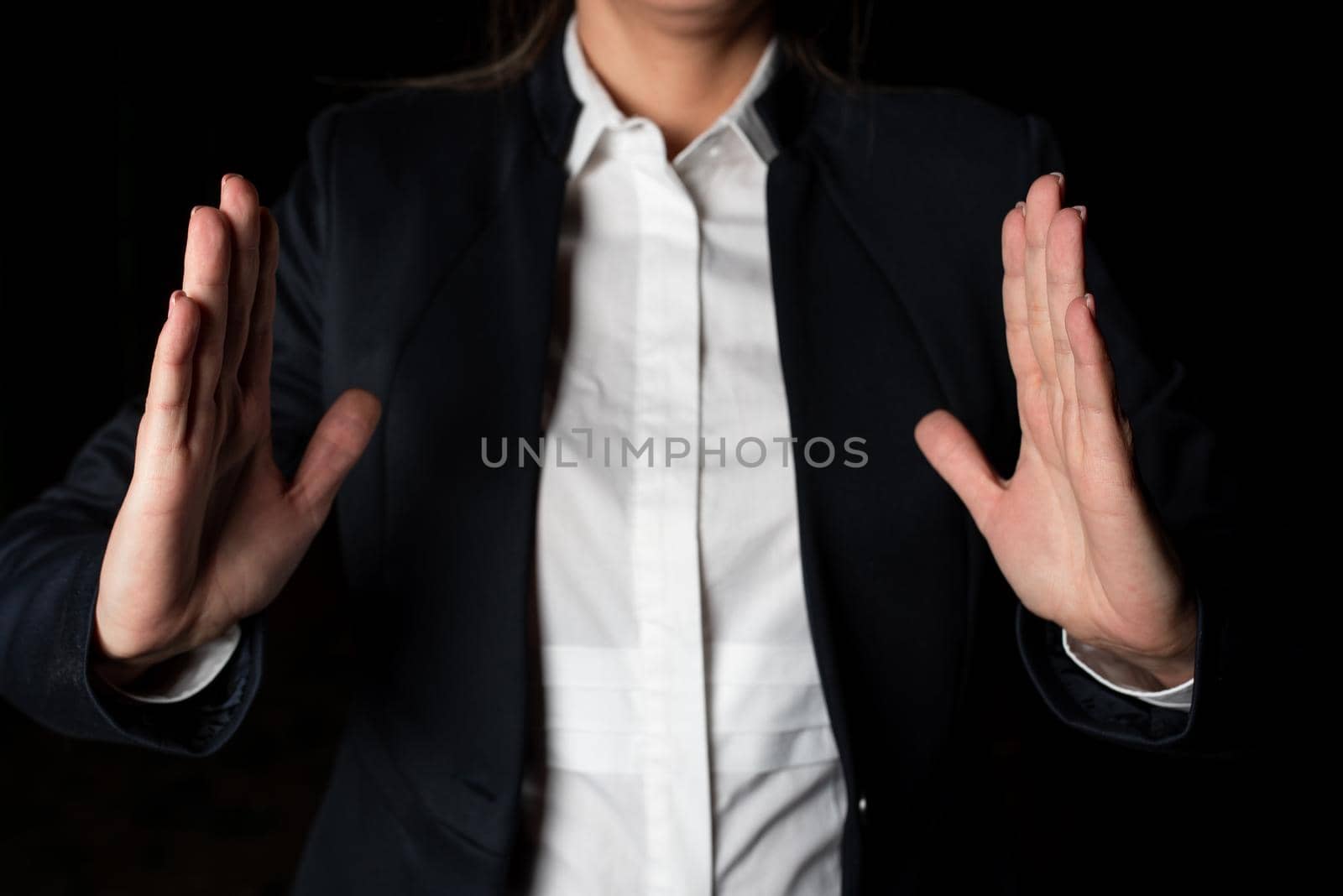 Businesswoman Holding Important Message Between Hands. Woman In Suit Showing New Crutial Idea Among Palms. Executive Presenting Updated Critical Information. by nialowwa