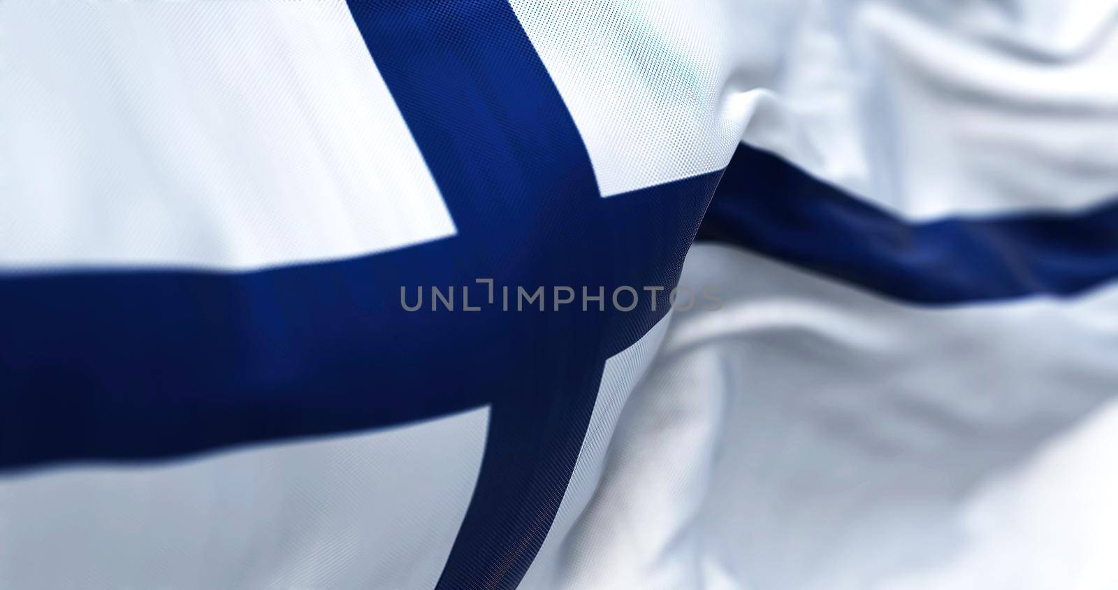 Close-up view of Finland national flag waving in the wind. Finland is a Scandinavian country located in northern Europe. Fabric background