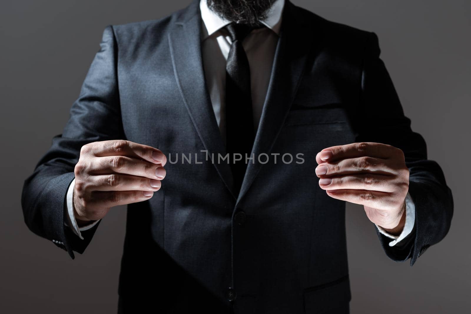 Businessman Holding Important Message Between Hands. Man In Suit Presenting Crutial Informations Among Palms. Executive Showing Recent Announcements. New Ideas Displayed. by nialowwa