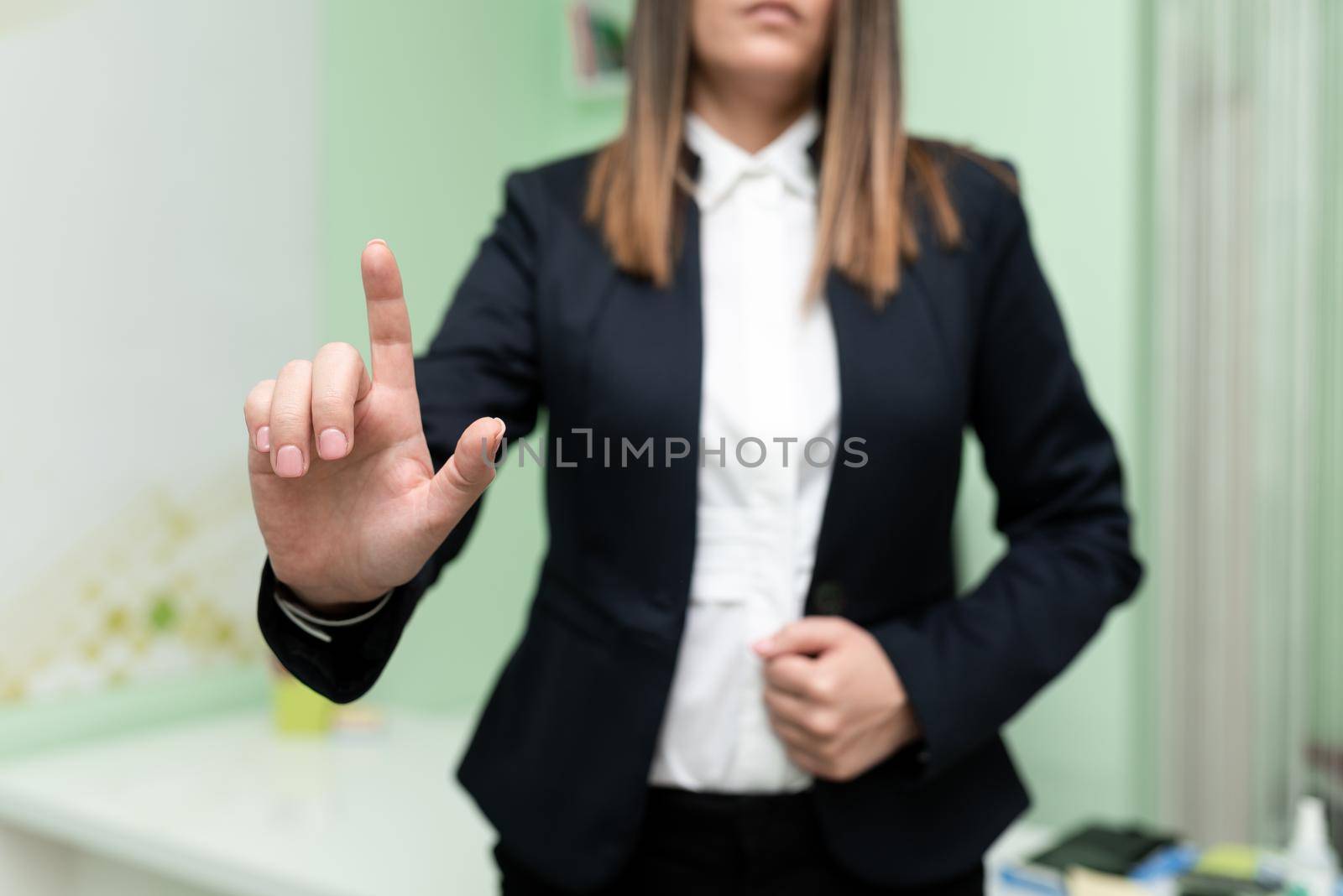 Businesswoman Pointing With One Finger On Important Messages. Executive In Suit Presenting Crutial Informations. Woman Showing Critical Announcements. by nialowwa