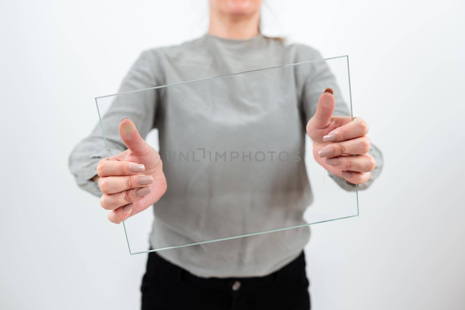Female Professional Holding Transparent Glass And Displaying Important Data. Woman Wearing Smart Casual Showing Banner While Promoting The Business For Progress. by nialowwa