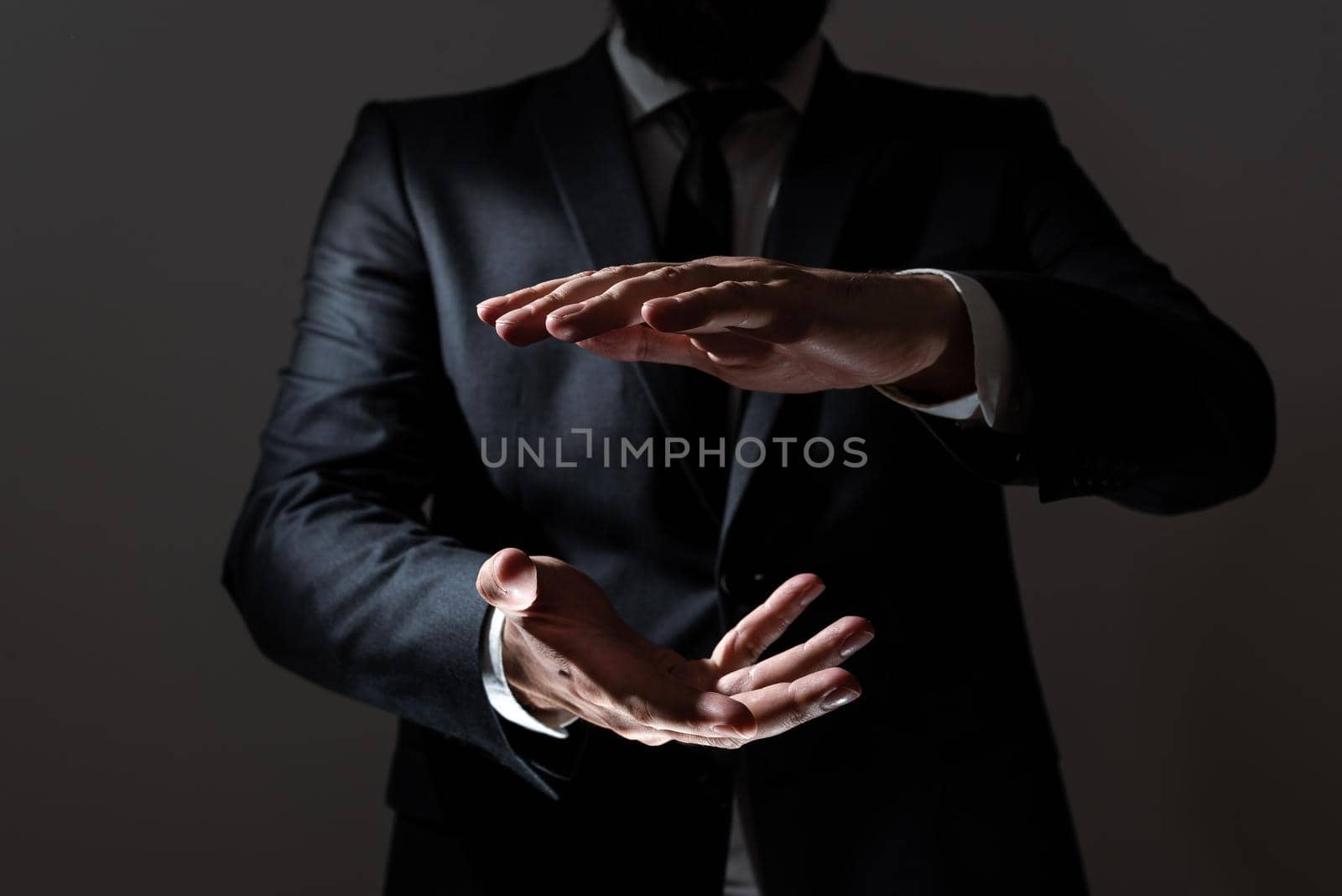 Businessman Pointing Important Message Between Hands. Man In Suit Presenting Crutial Informations Among Palms. Executive Showing Recent Announcements. New Ideas Displayed. by nialowwa