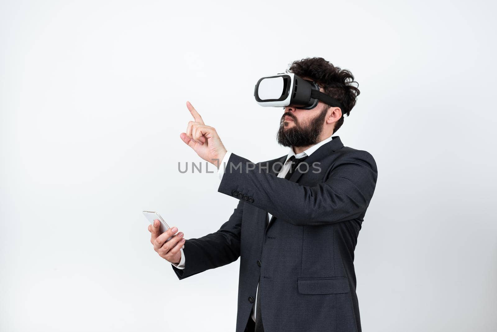 Man Wearing Vr Glasses And Pointing On Important Messages With One Finger. Businessman Having Virtual Reality Eyeglasses And Showing Crutial Informations. by nialowwa