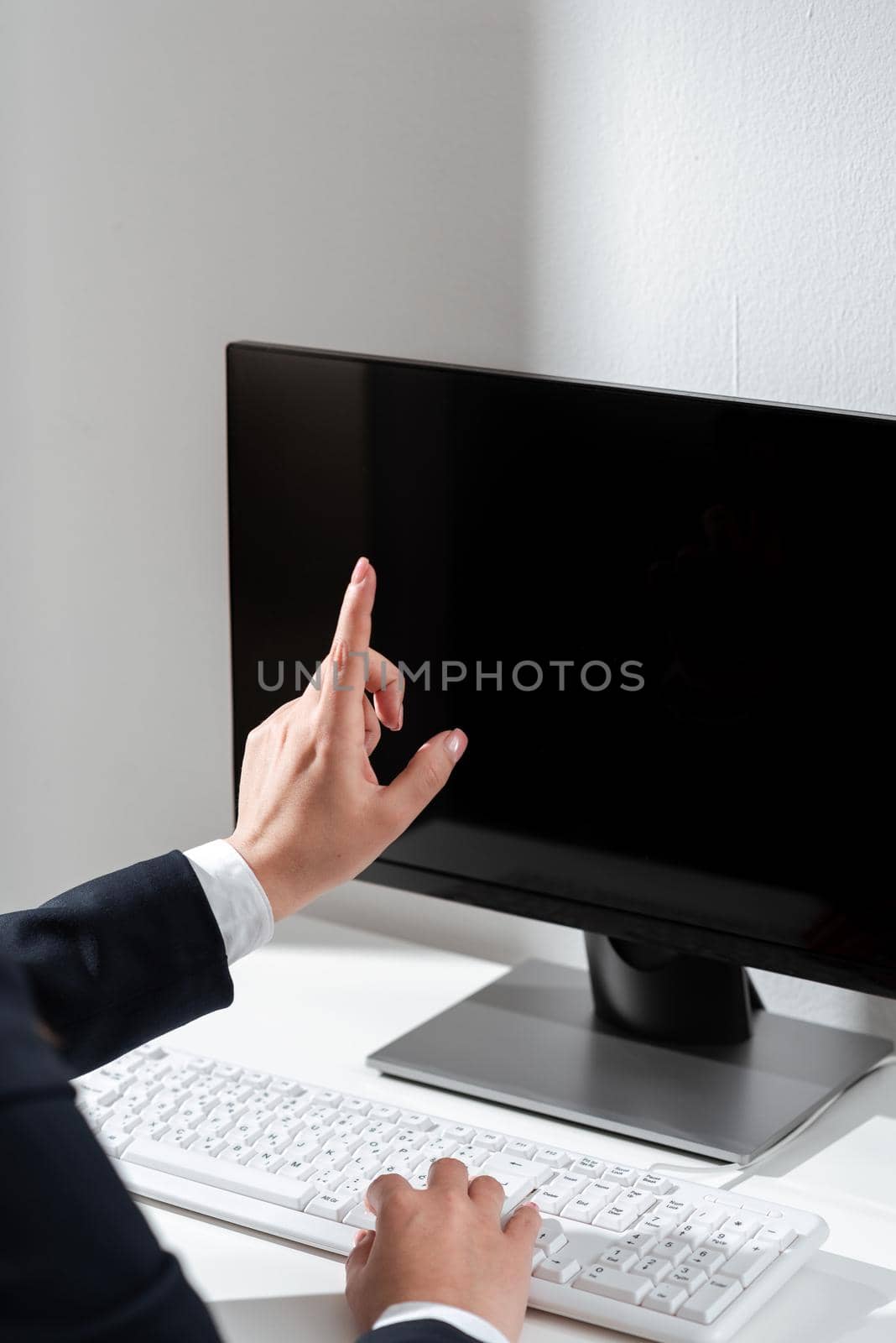 Businesswoman Typing Recent Updates On Lap Top Keyboard On Desk And Pointing Important Ideas With One Finger. Woman In Office Writing Late Messages On Computer. by nialowwa