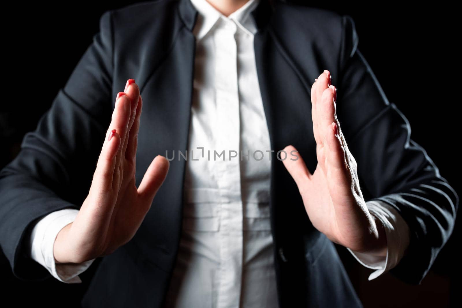 Businesswoman Holding Important Message Between Hands. Woman In Suit Showing New Crutial Idea Among Palms. Executive Presenting Updated Critical Information. by nialowwa