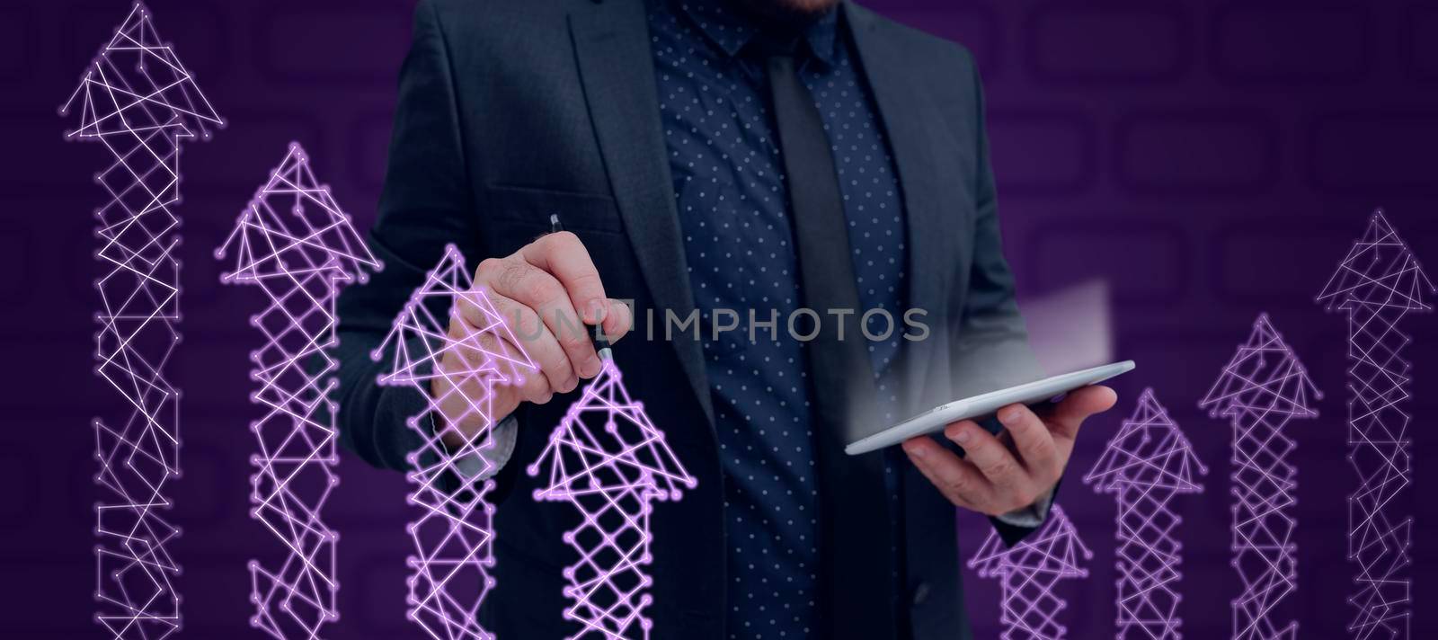 Businessman Wearing Suit Holding Tablet And Pen Drawing Arrows Going Up With Digitally Generated Network . Man Presenting Ideas For The Achievement Of Business Goals. by nialowwa