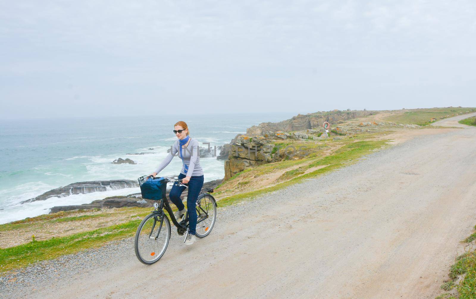 Young lady with bicycle on a sea coast