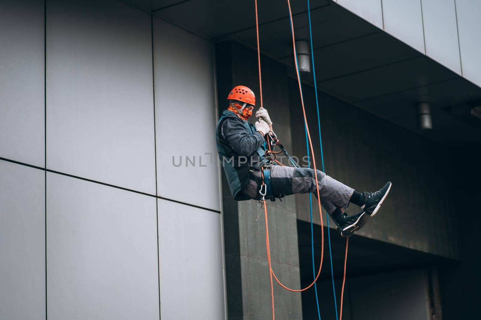 Industrial climber in uniform and helmet rises. Outdoor