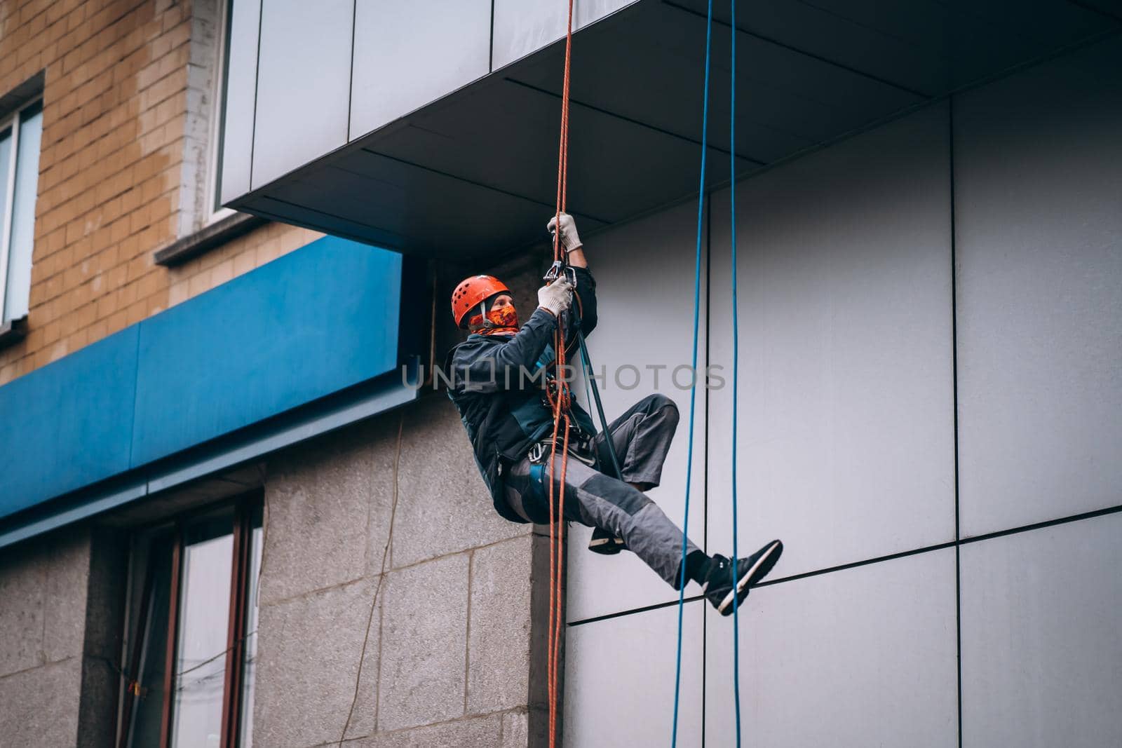 Industrial climber in uniform and helmet rises. Outdoor