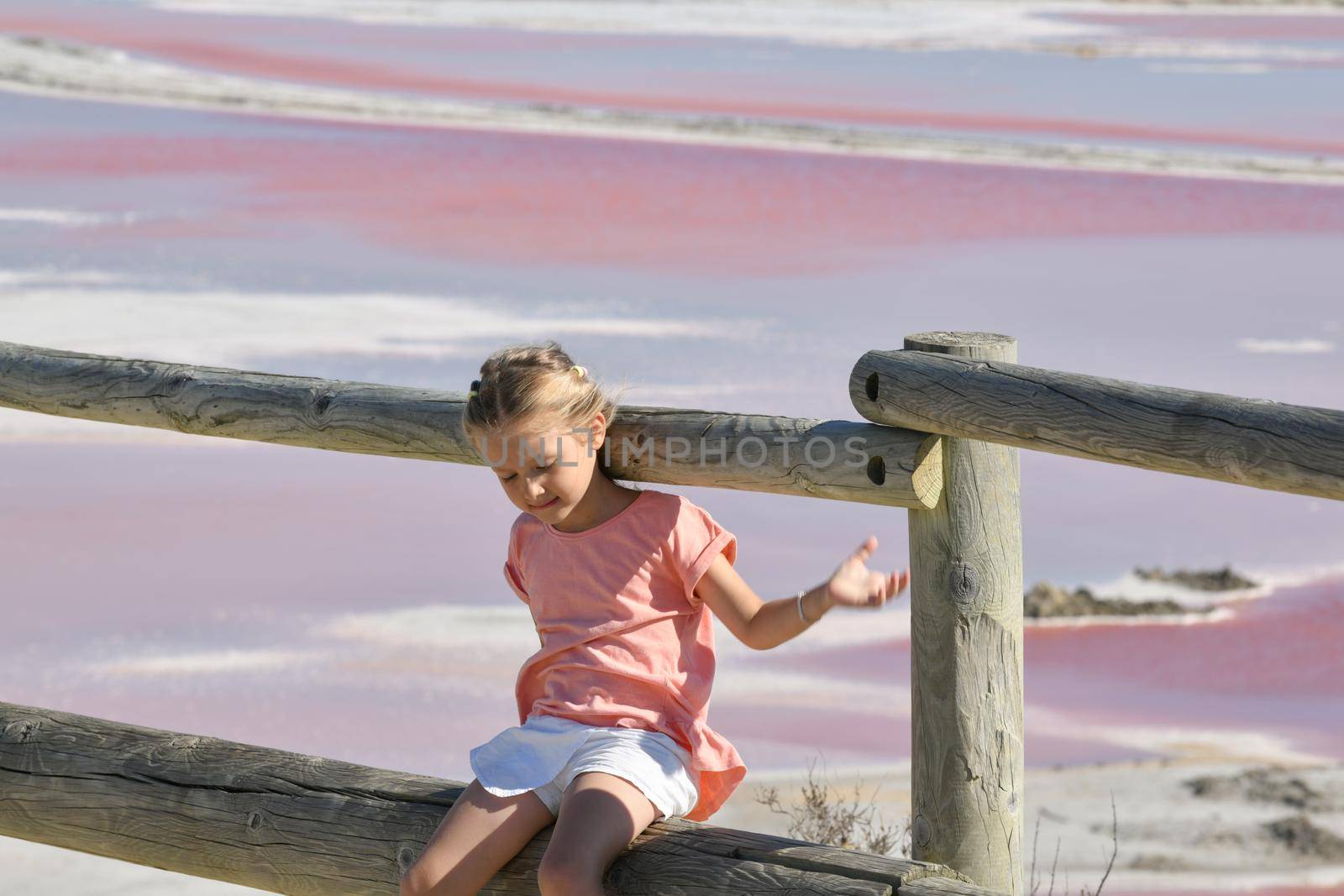 A girl at the Salin-de-Giraud salt farm with pink purple salty water