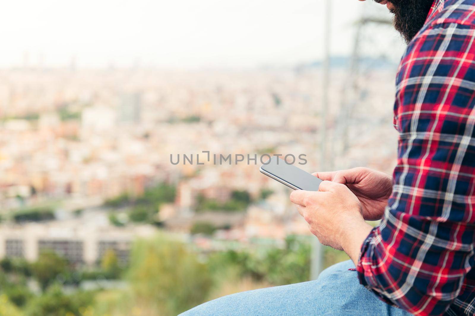 detail of the hands of a seated man consulting the mobile phone, concept of freedom and technology, copy space for text