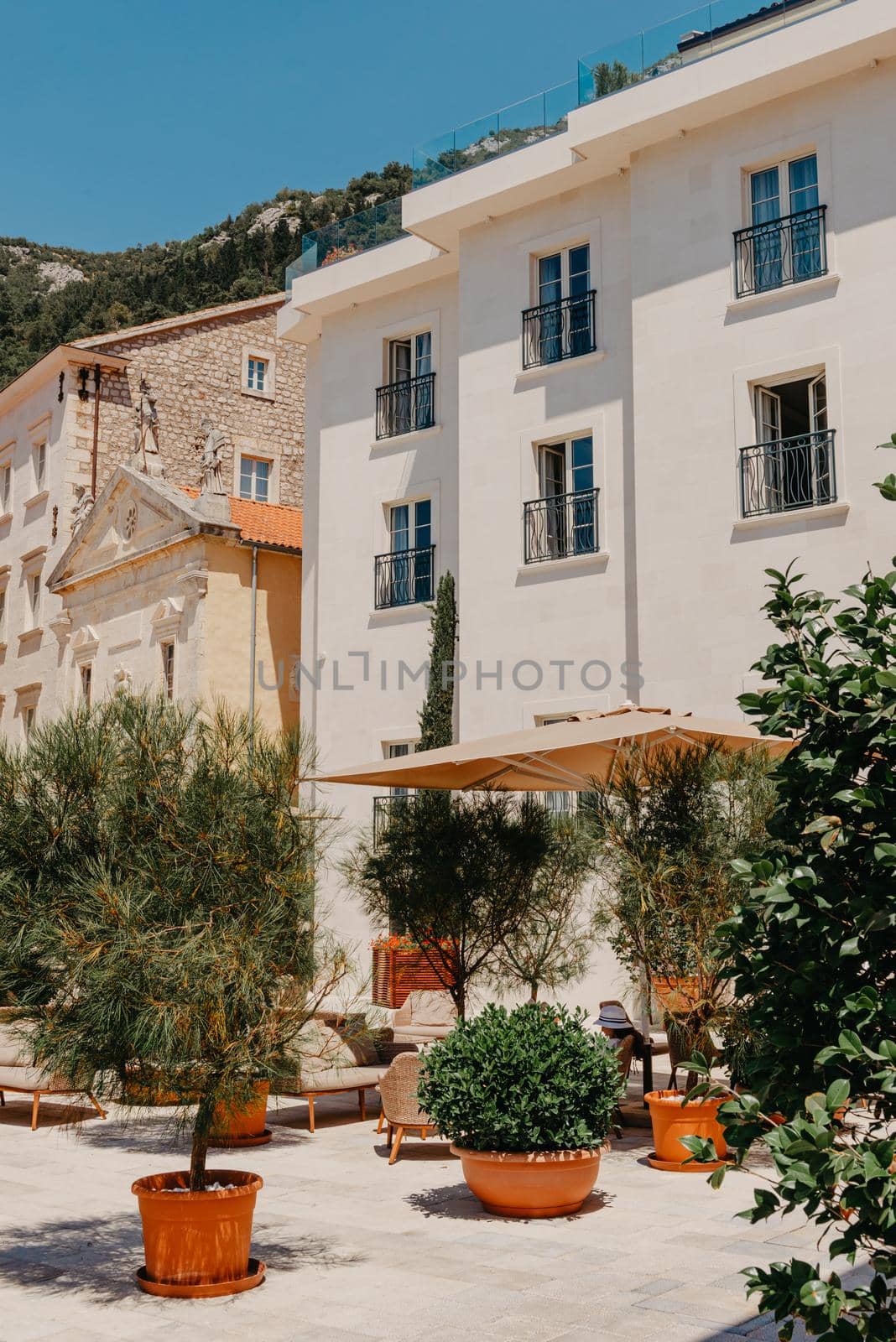 Historic city of Perast at Bay of Kotor in summer, Montenegro. Scenic panorama view of the historic town of Perast at famous Bay of Kotor with blooming flowers on a beautiful sunny day with blue sky and clouds in summer, Montenegro, southern Europe by Andrii_Ko