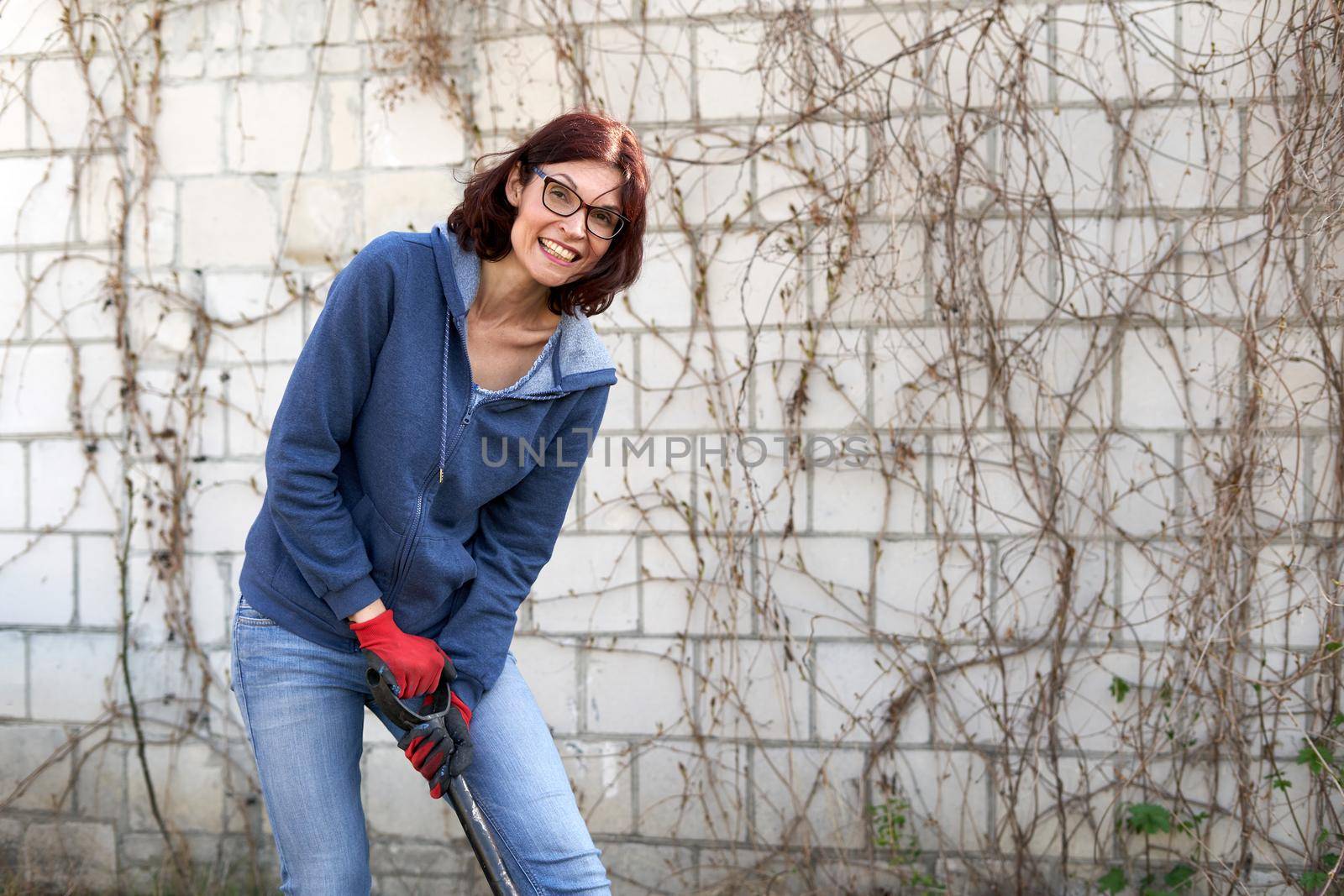 Portrait of a woman smiling to the camera while ploughing the land