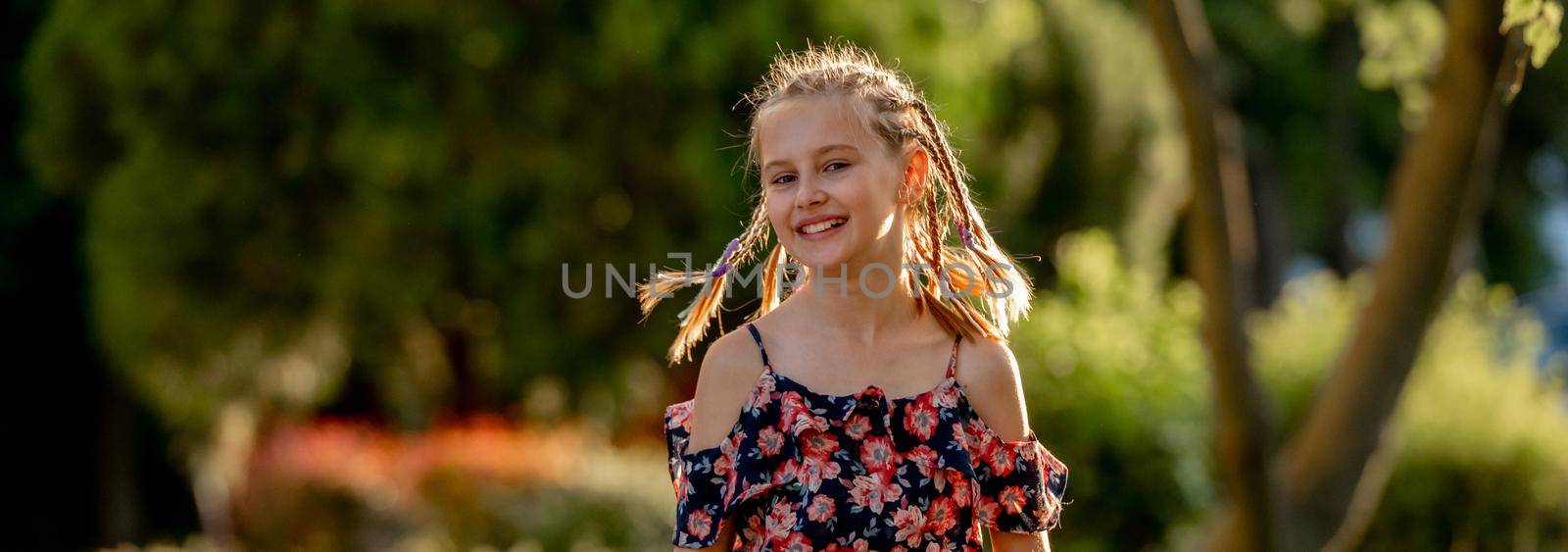 Little girl smiling in sunny spring day outdoors portrait. Cute child kid at nature