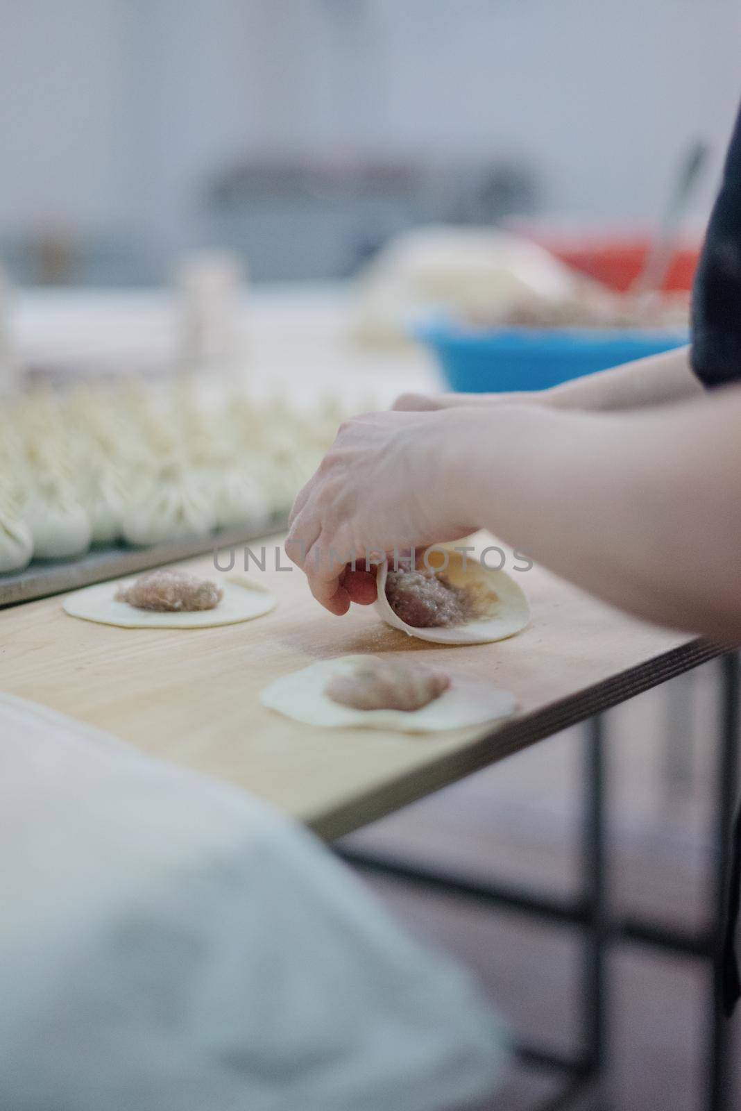 Front view of woman's hands making meat dumpling. The process of making homemade dumplings. Minced meat on dough, the process of cooking italian ravioli. Russian food.