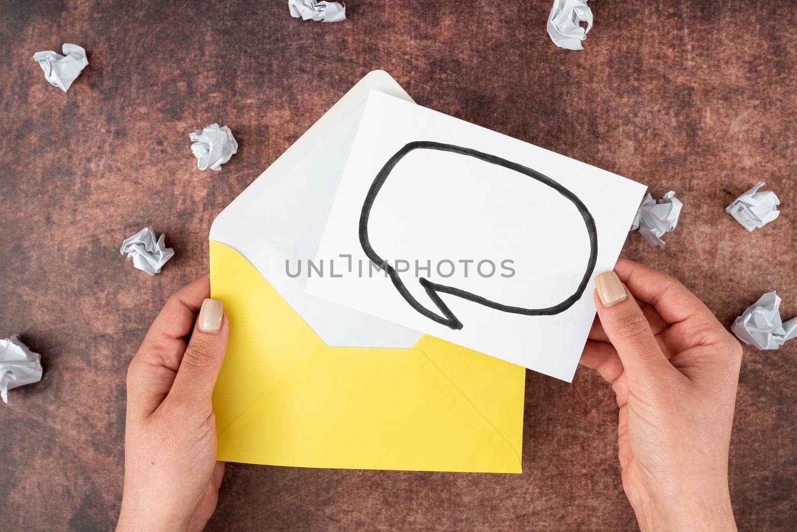Hands Of Woman Holding Thought Bubble Sheet With Envelope On Table.