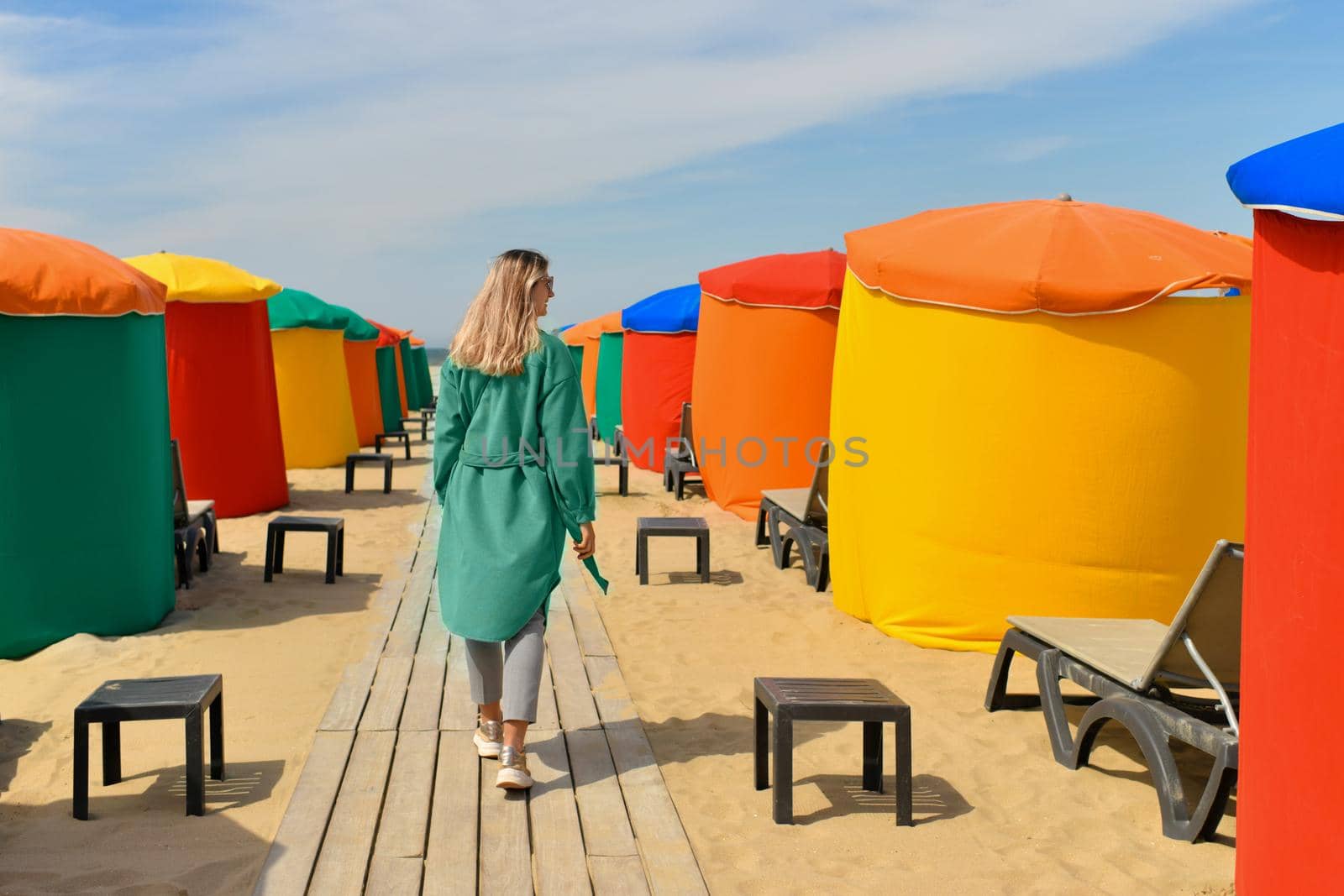 A woman near the typical colored tents and beach chairs