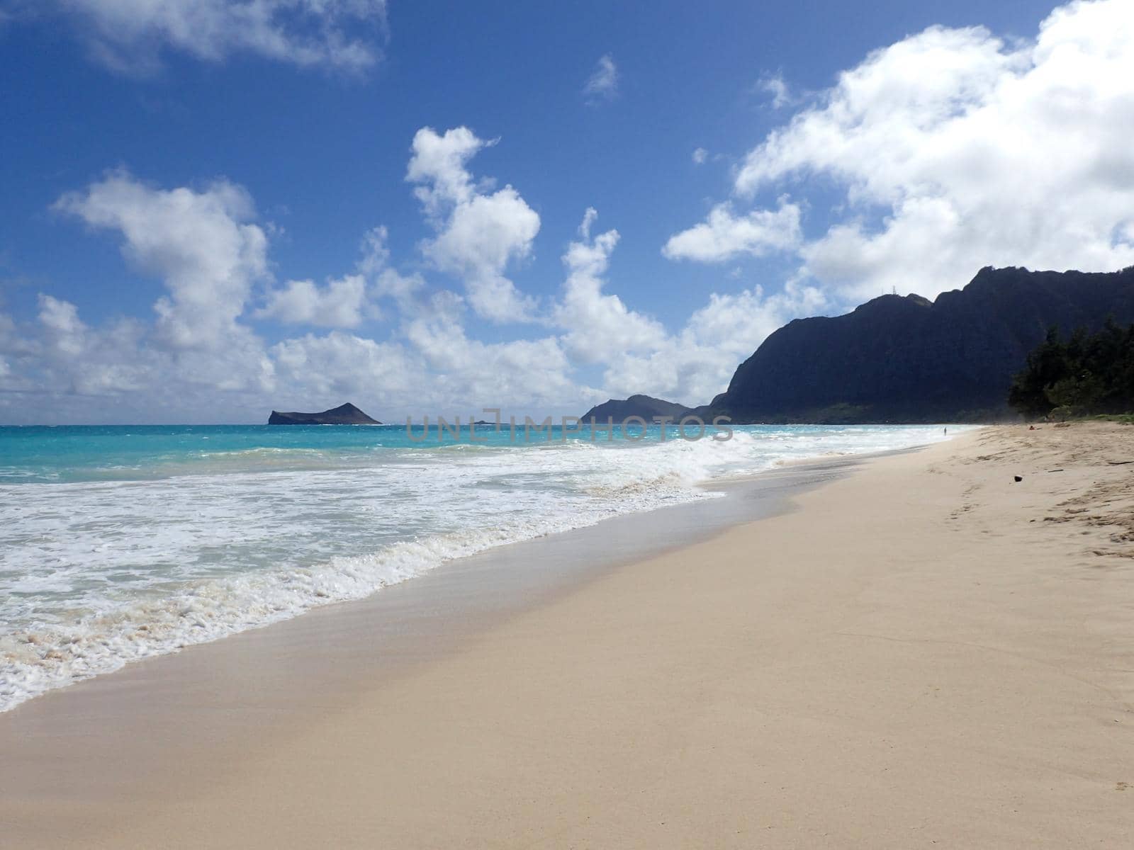 Gentle wave lap on Waimanalo Beach looking towards Rabbit island and Rock island on a nice day Oahu, Hawaii.  January 2017.