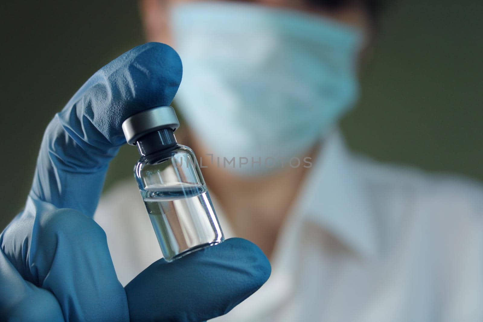 A female doctor holds a vial of vaccine in her hand. Hand close up..