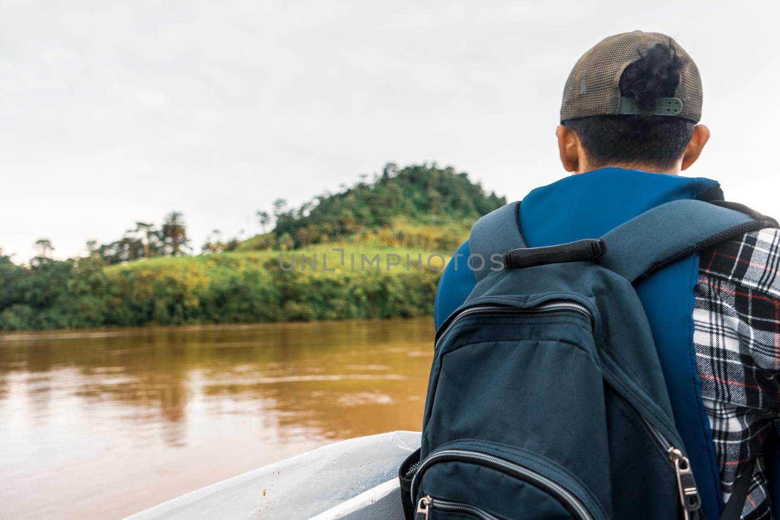 Latino man sailing a boat down a muddy river in El Rama, Nicaragua