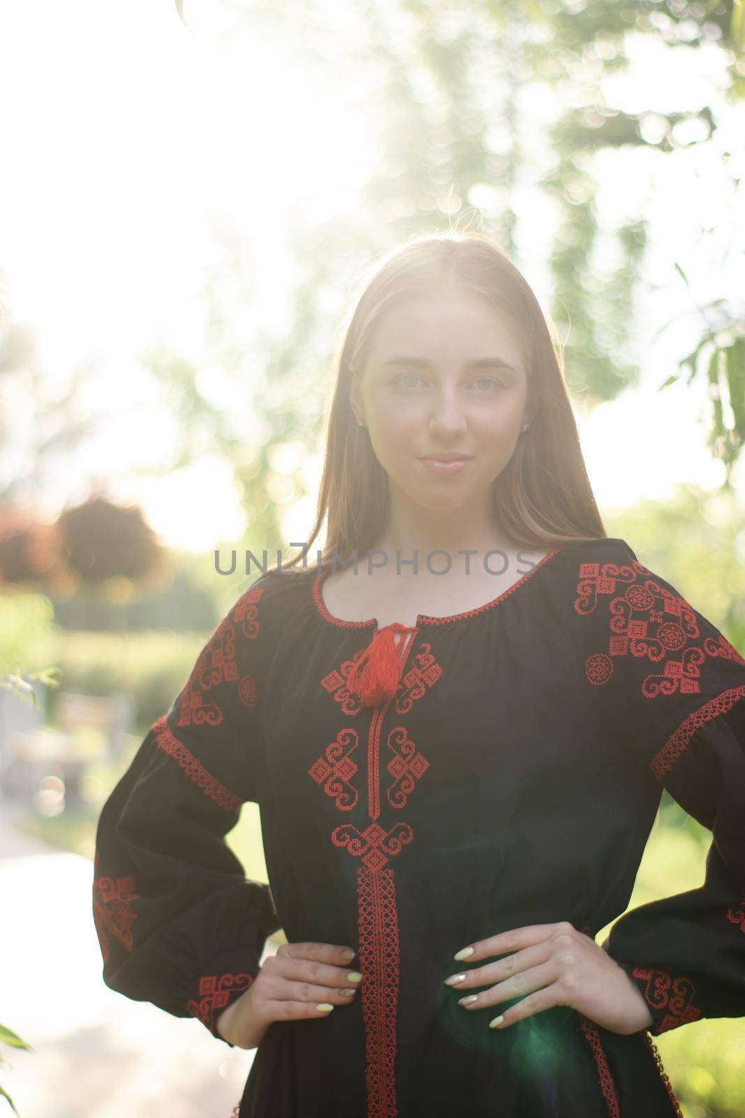 portrait of young woman wearing black and red vyshyvanka. national embroidered Ukrainian shirt. girl in dress outdoors in park. summer.