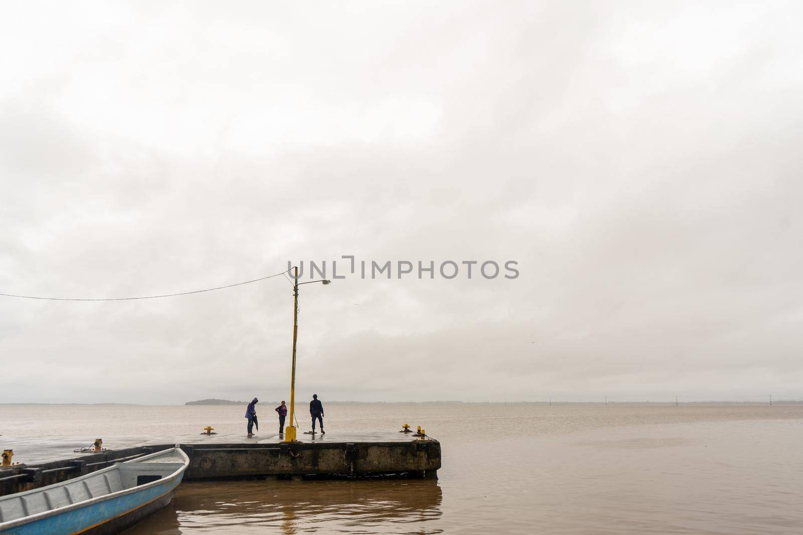 Unrecognizable people walking on a rainy day at the pier of Bluefields, Caribbean Coast of Nicaragua