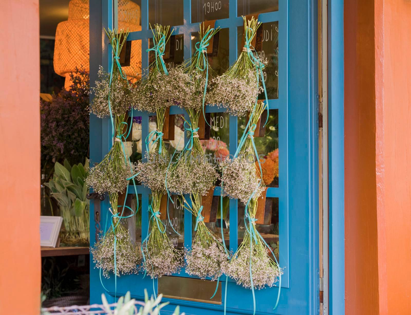 Bouquet of dried flowers hanging on the blue door Provence