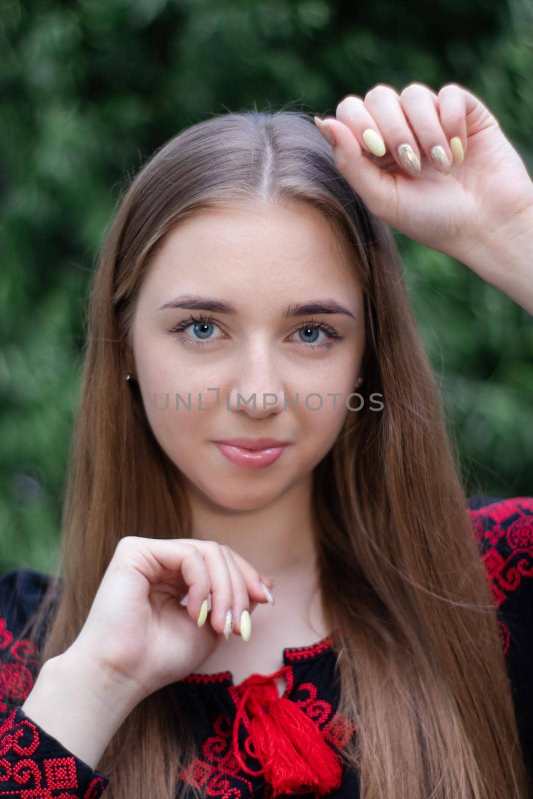 portrait of young woman wearing black and red vyshyvanka. national embroidered Ukrainian shirt. girl in dress outdoors in park. summer.