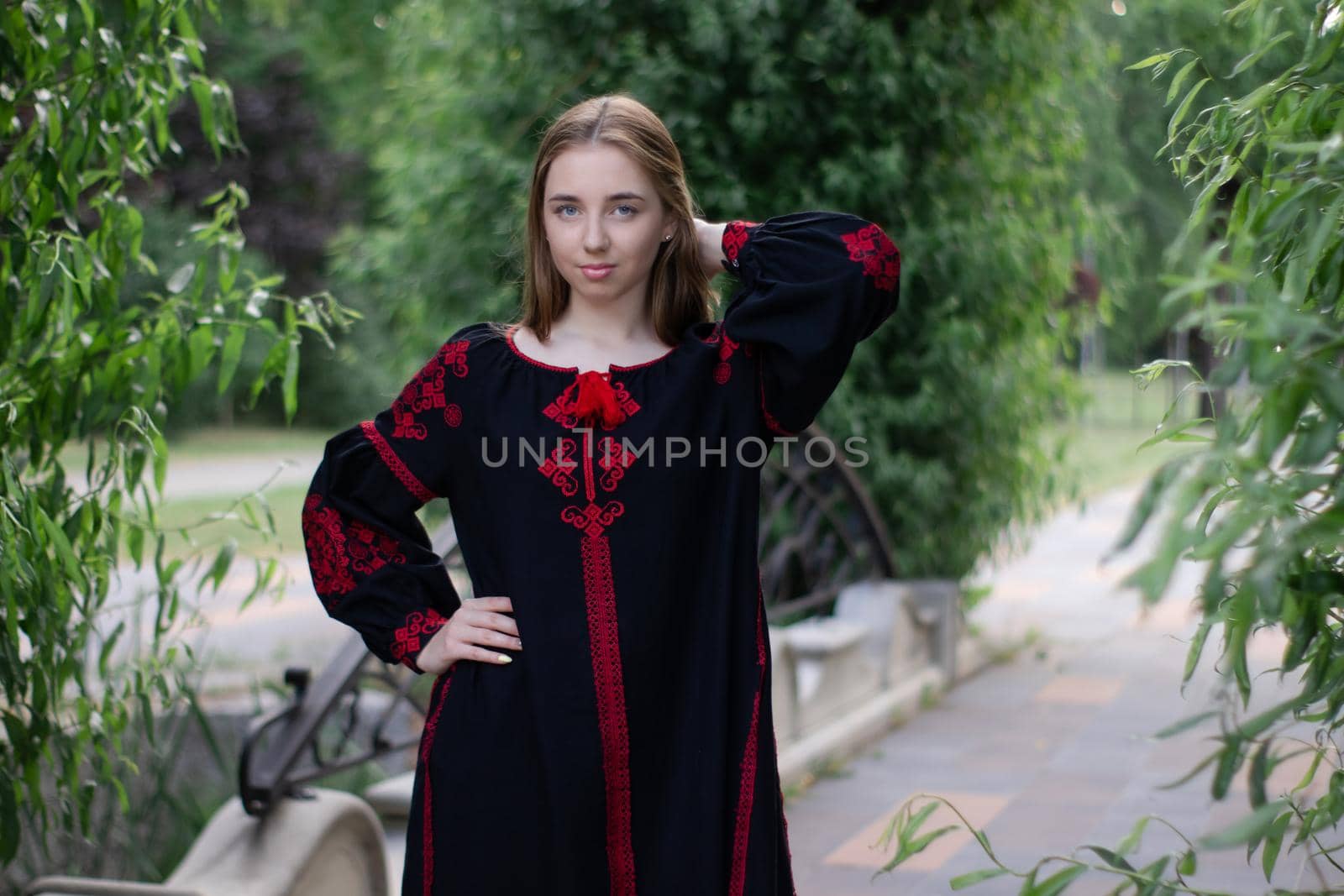 girl in national traditional ukrainian clothes. black and red embroidered dress. woman model posing in park outdoors by oliavesna