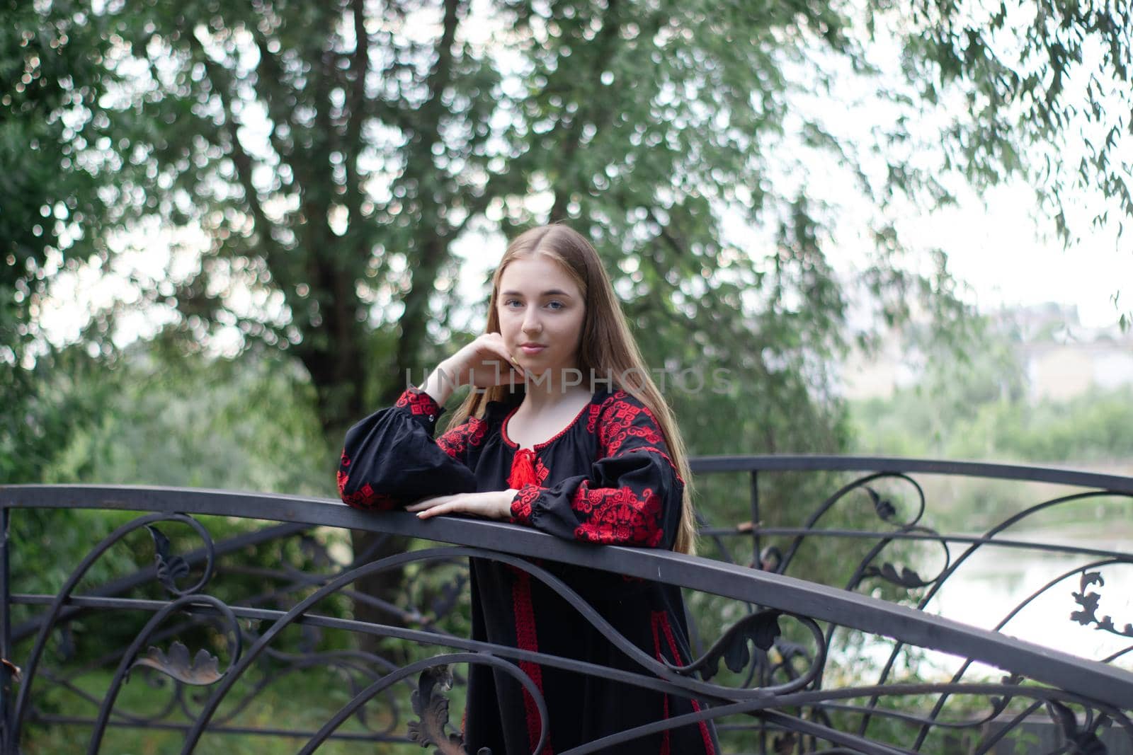 girl in national traditional ukrainian clothes. black and red embroidered dress. woman model posing in park outdoors by oliavesna