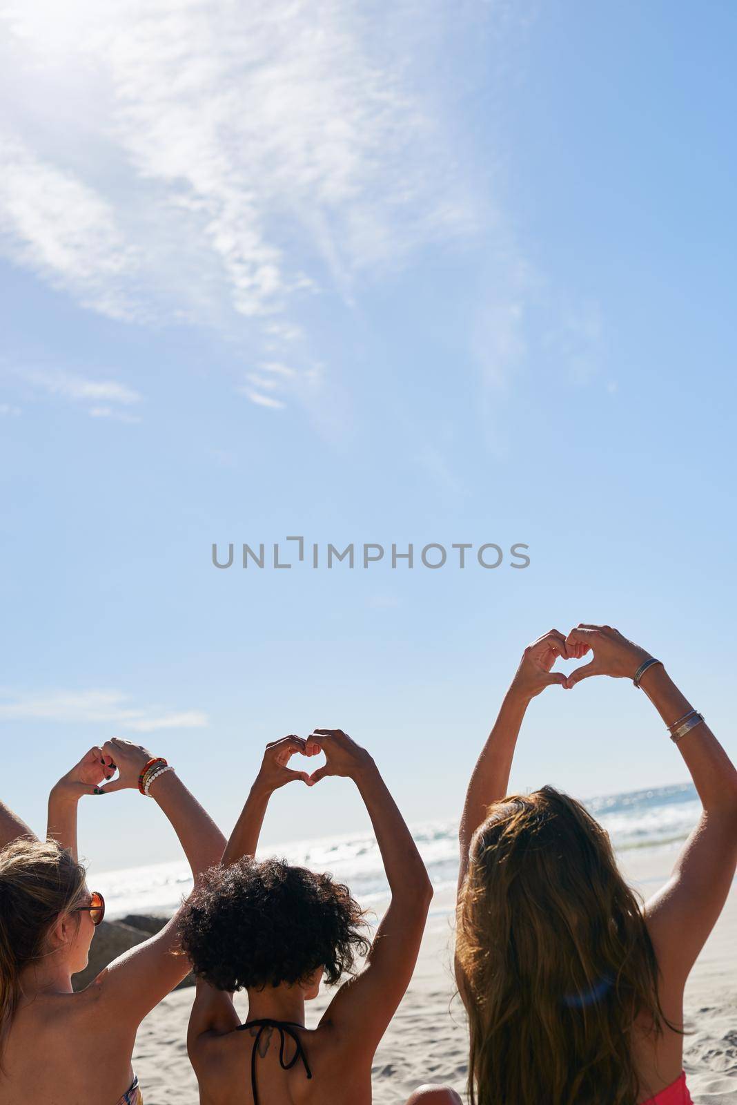 a group of friends with their hands in the air creating heart shapes.