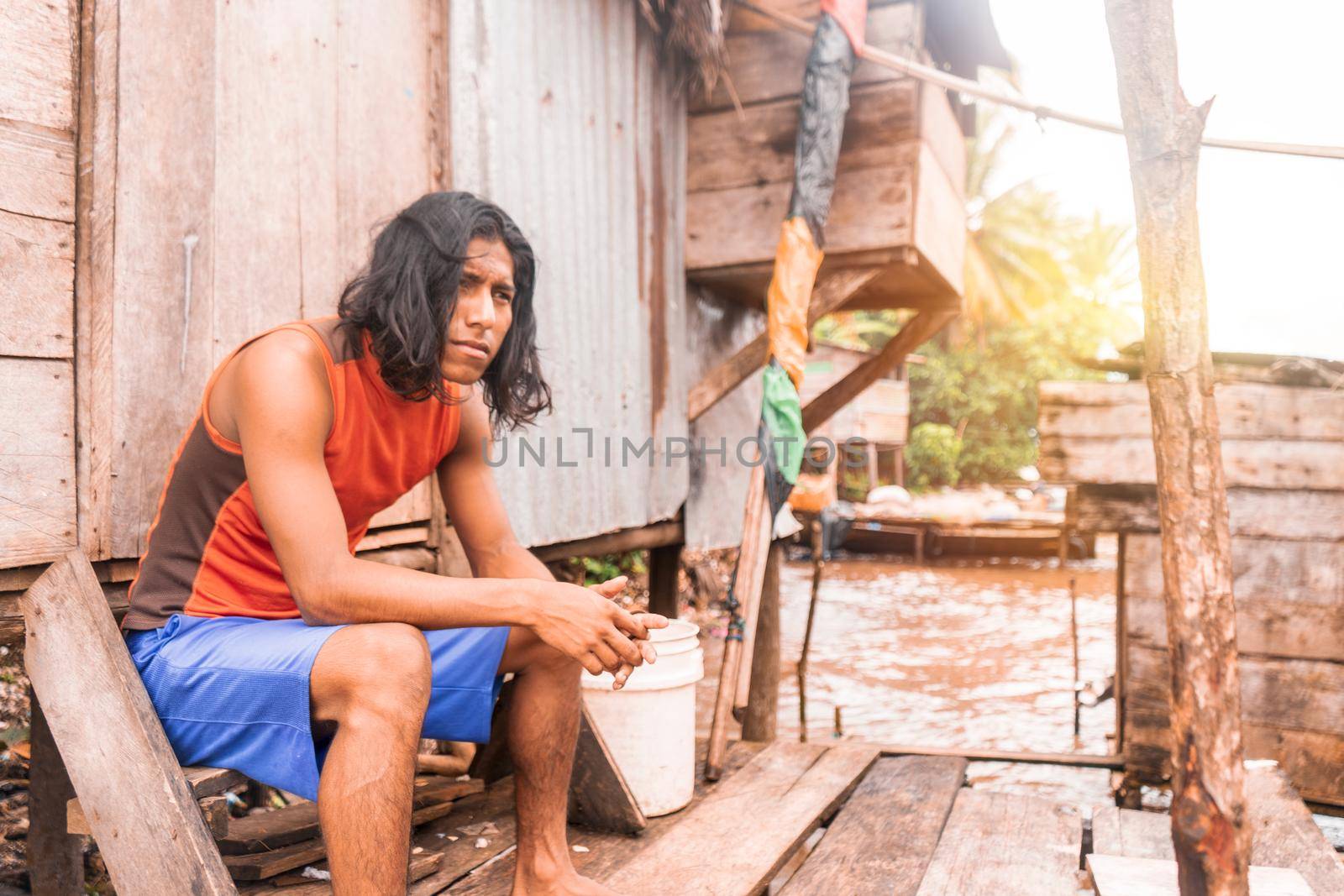 Long haired indigenous teenager sitting in a cabin on the coast of the pacific sea in Bluefields Nicaragua