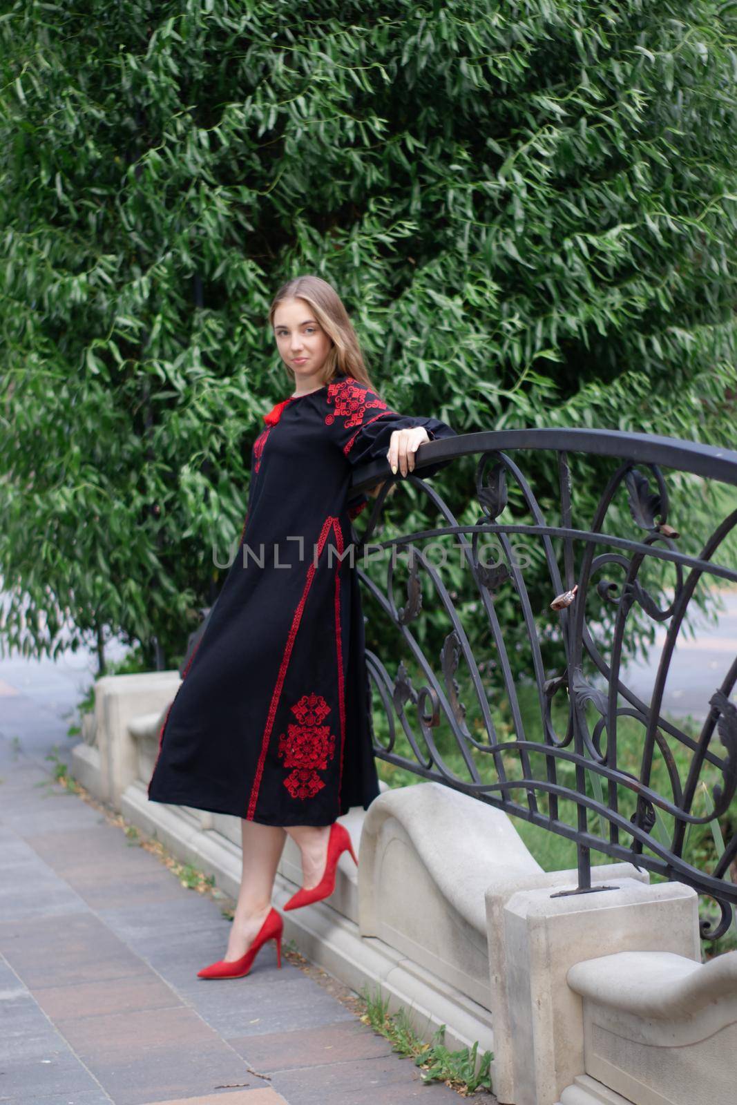portrait of young woman wearing black and red vyshyvanka. national embroidered Ukrainian shirt. girl in dress outdoors in park. summer by oliavesna