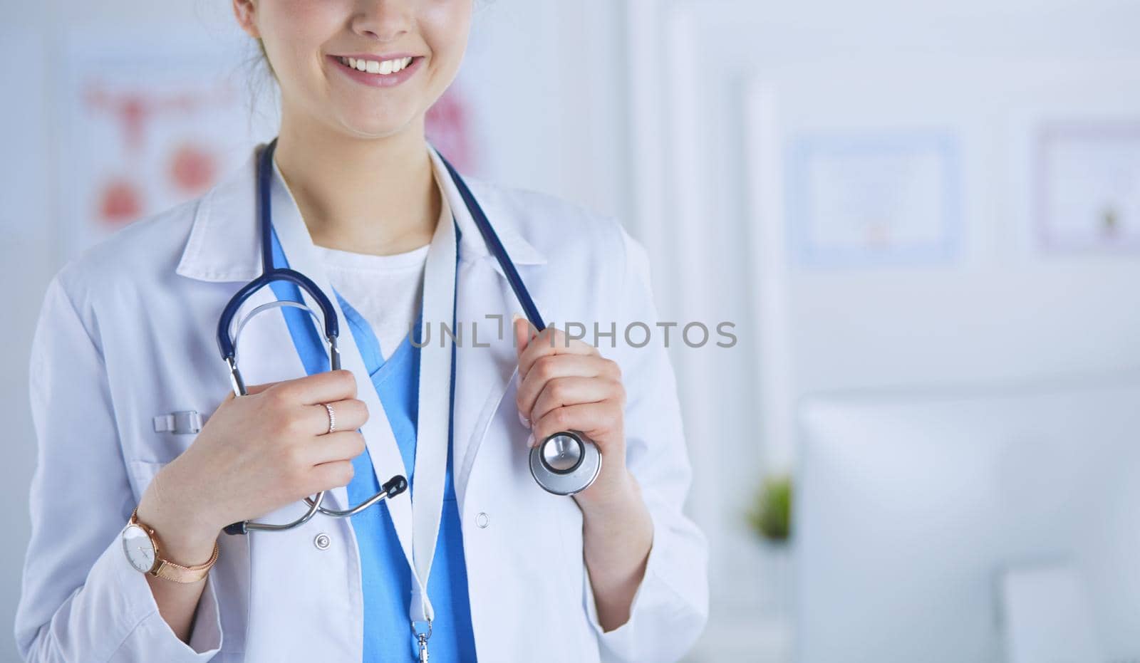 Portrait of young woman doctor with white coat standing in hospital.