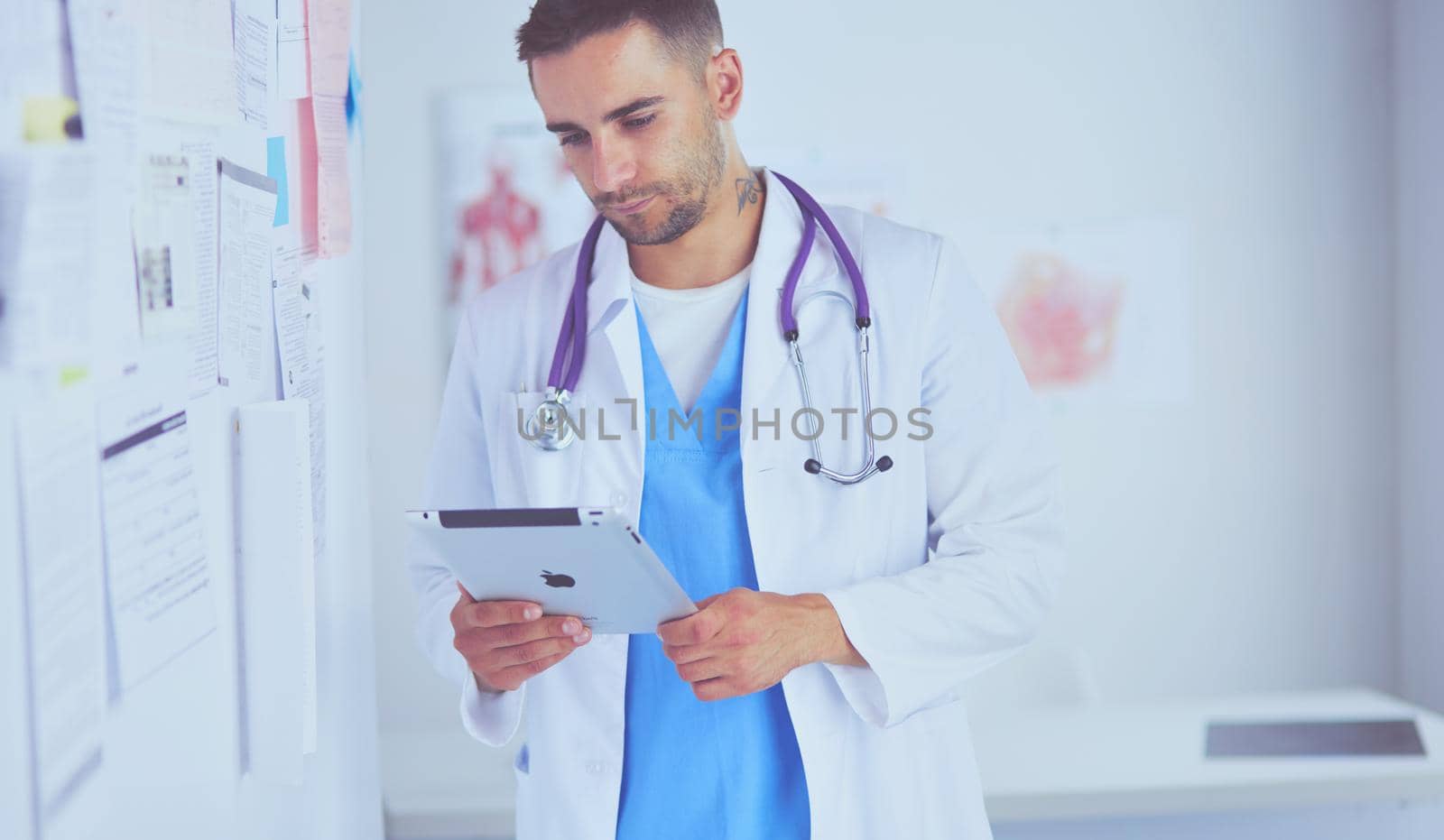 Young and confident male doctor portrait standing in medical office