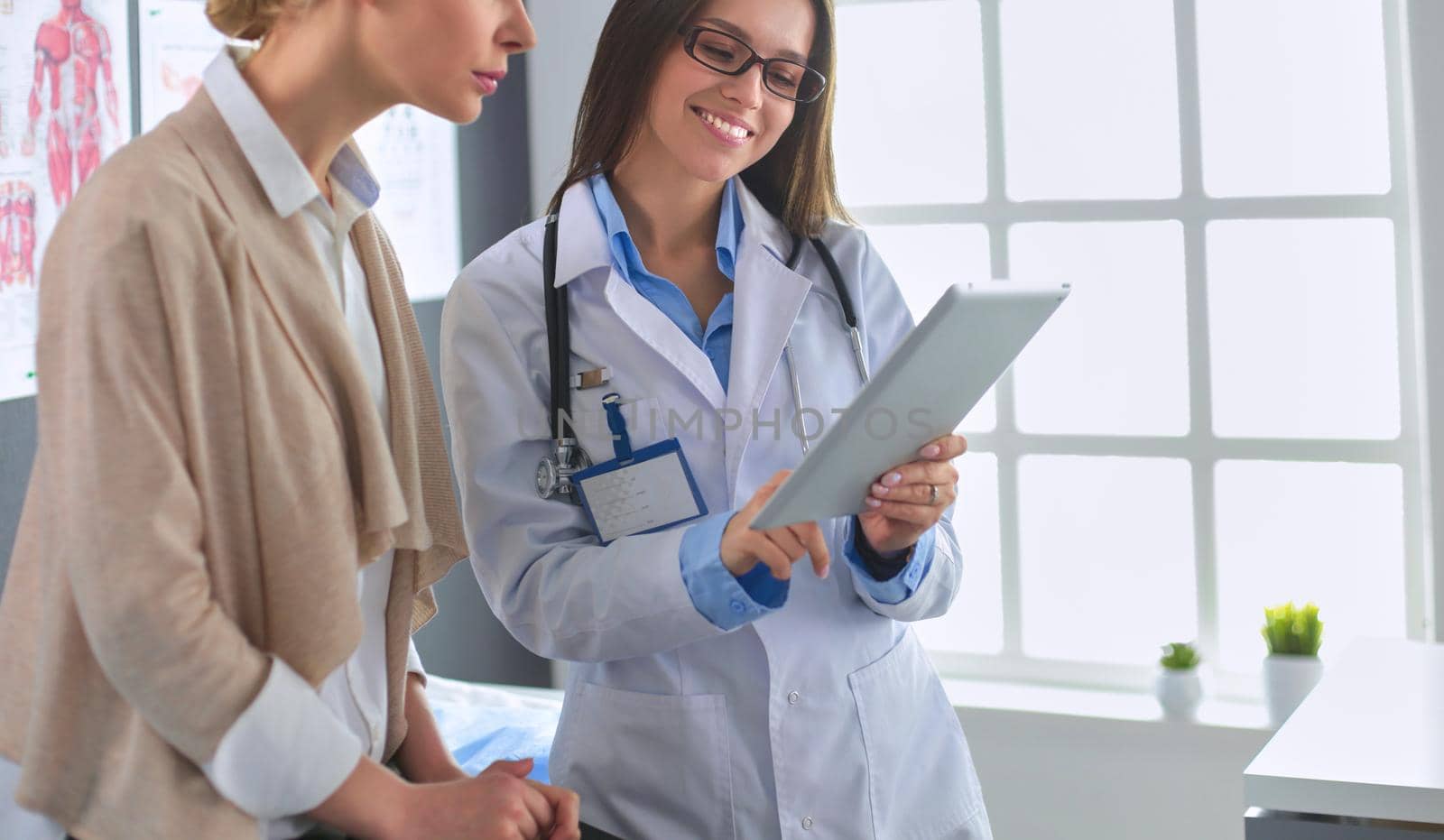 Doctor and patient discussing something while sitting at the table . Medicine and health care concept.