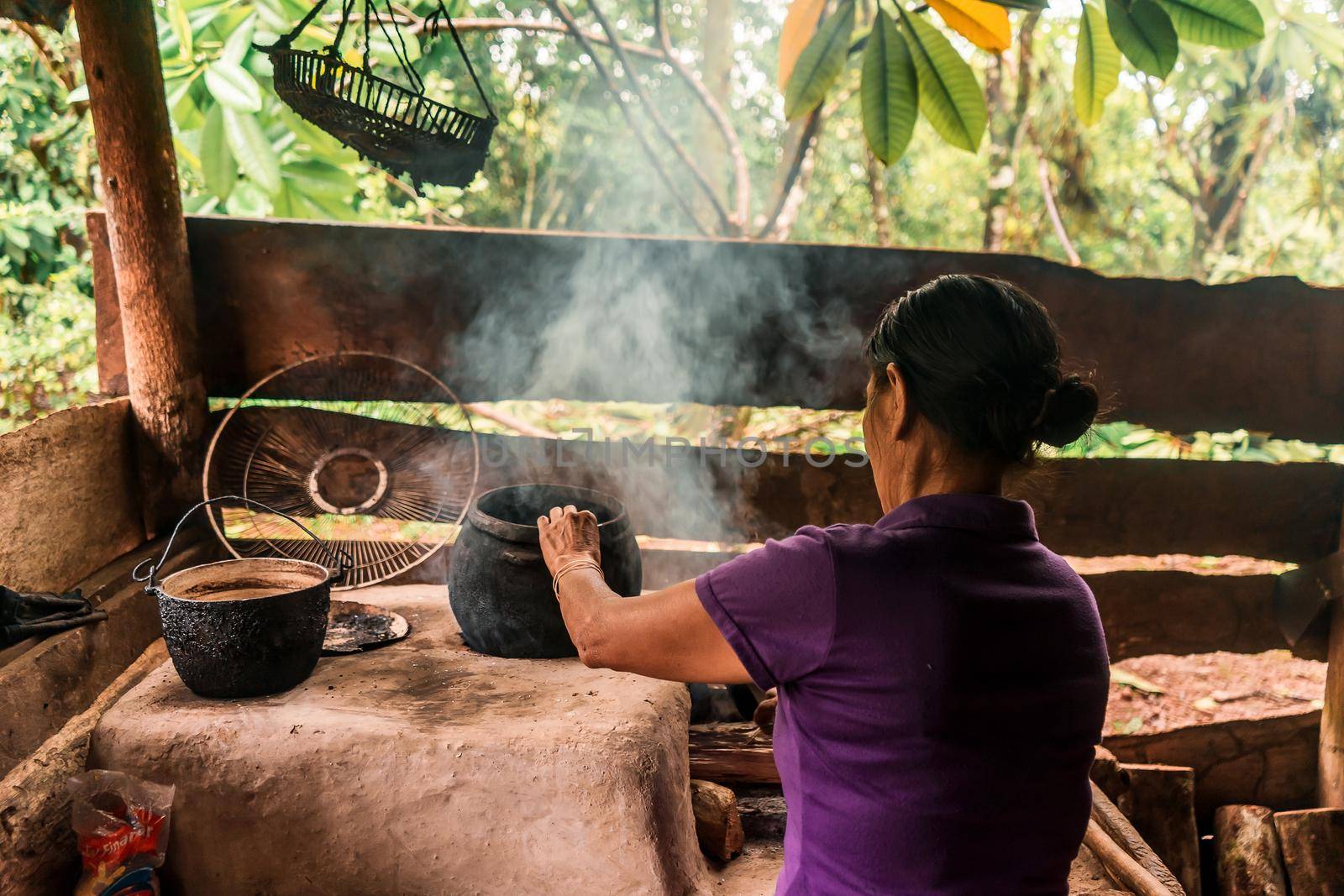 Latin grandmother with arms cooking in pots on the stove at home in Nueva Guinea Nicaragua