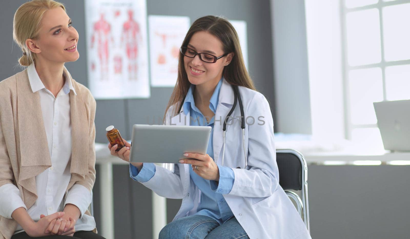 Doctor and patient discussing something while sitting at the table . Medicine and health care concept.
