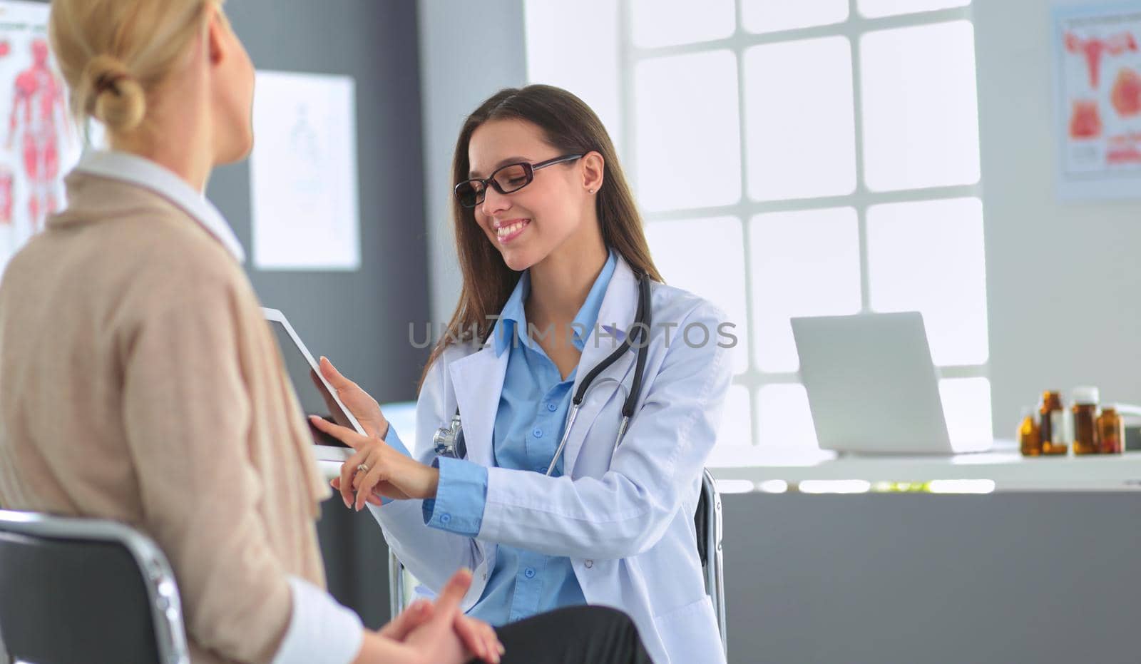Doctor and patient discussing something while sitting at the table . Medicine and health care concept.
