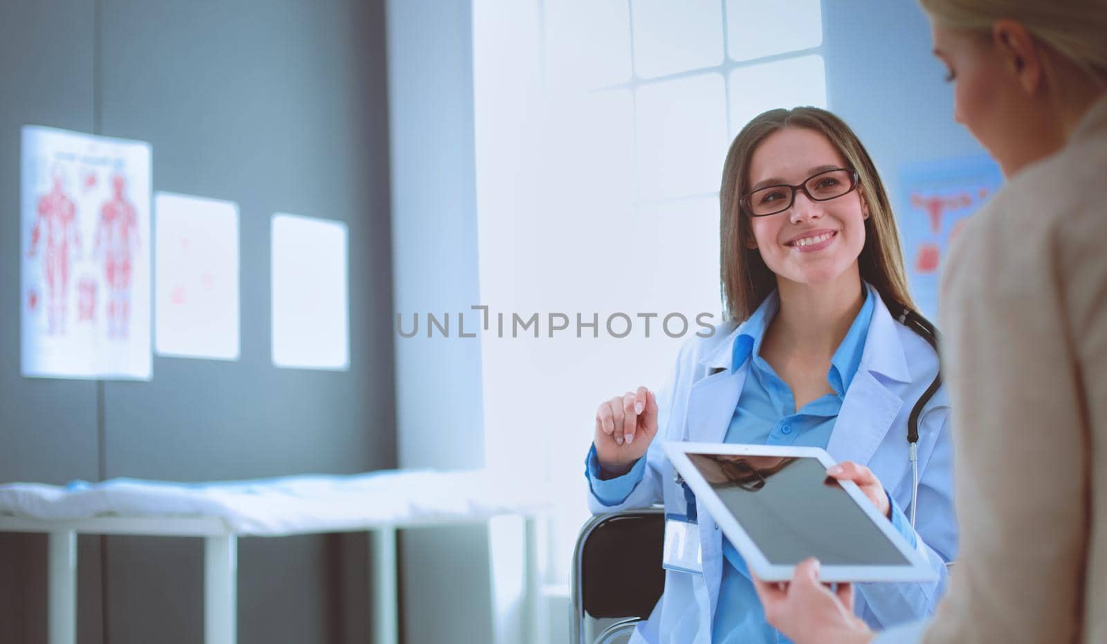 Doctor and patient discussing something while sitting at the table . Medicine and health care concept.
