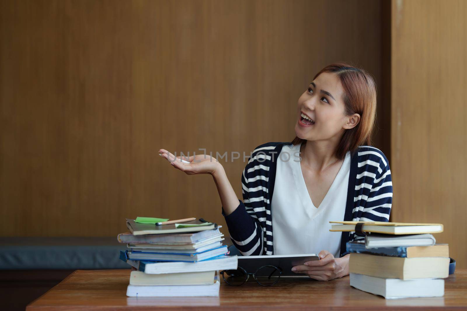 Image of Young woman reading a book for exam at library at school. back to school concept