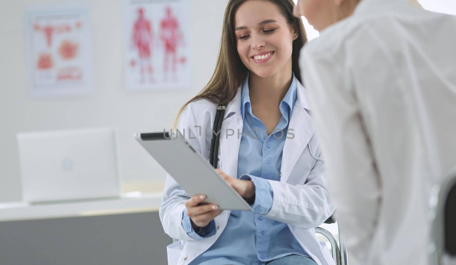 Doctor and patient discussing something while sitting at the table . Medicine and health care concept.