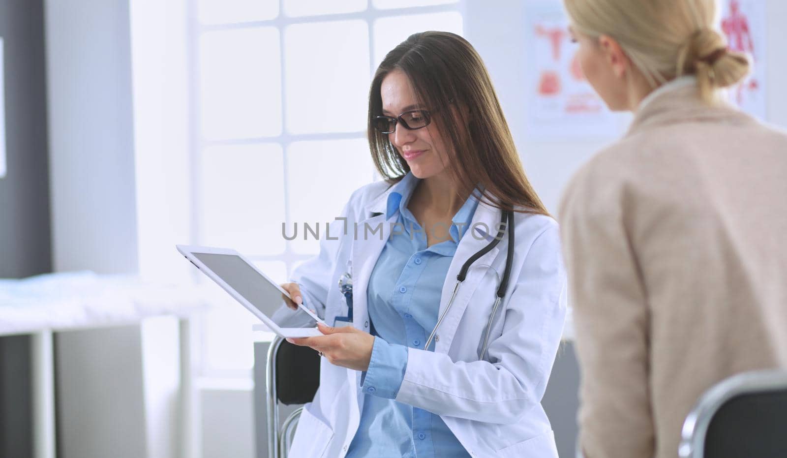 Doctor and patient discussing something while sitting at the table . Medicine and health care concept.
