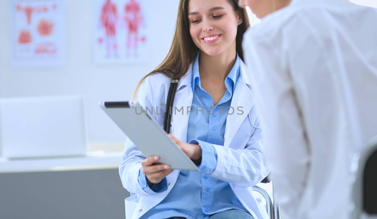 Doctor and patient discussing something while sitting at the table . Medicine and health care concept.
