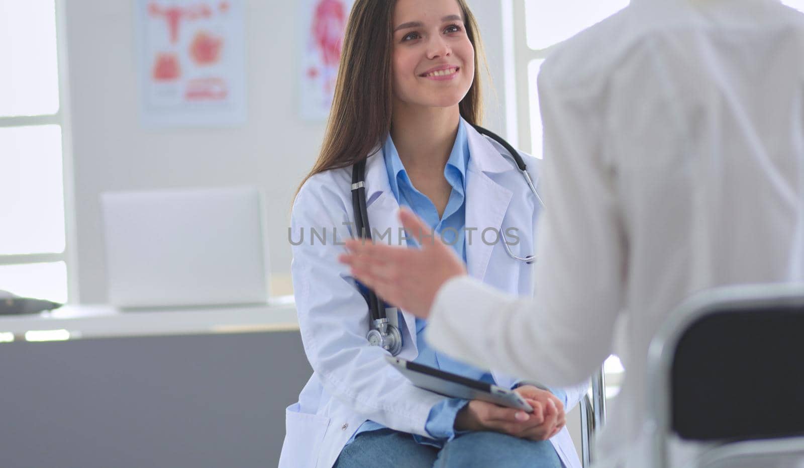 Doctor and patient discussing something while sitting at the table . Medicine and health care concept.