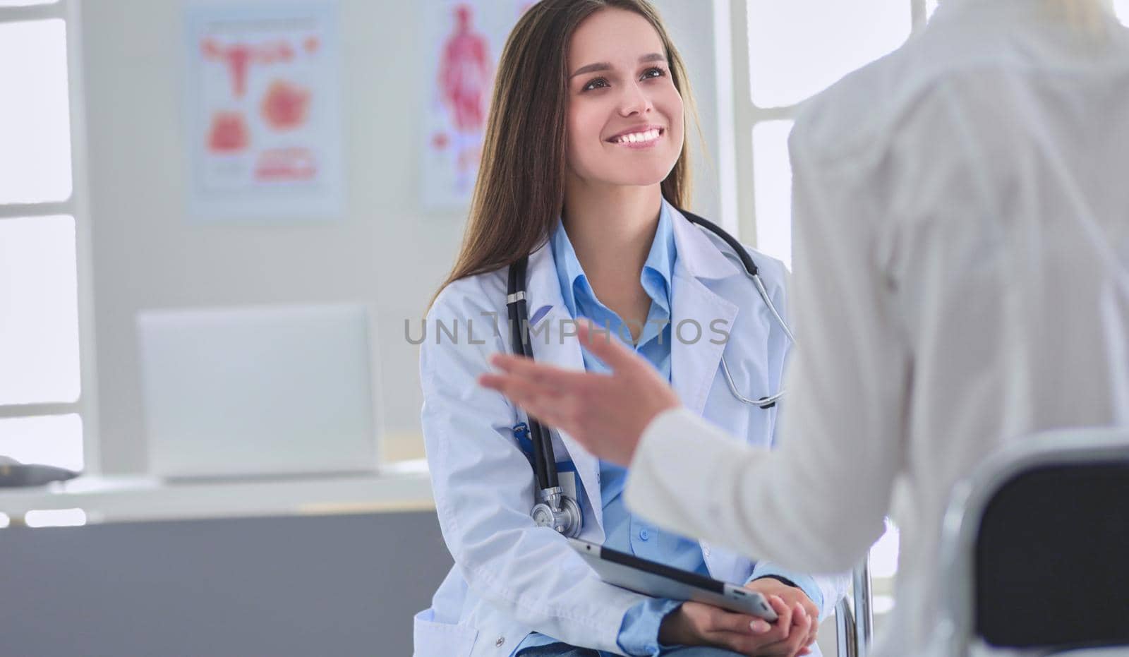 Doctor and patient discussing something while sitting at the table . Medicine and health care concept.